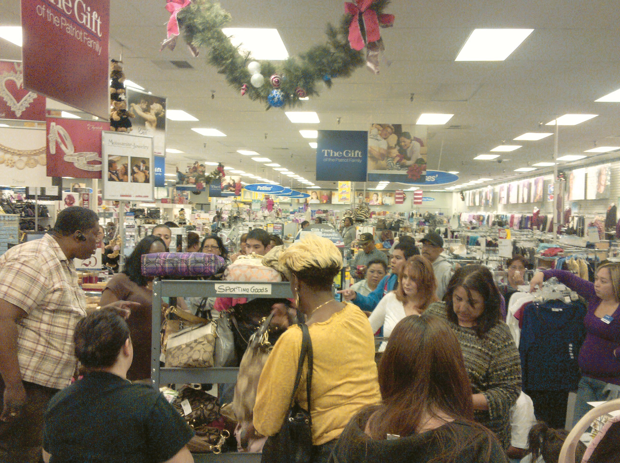 Shoppers crowd a cart of handbags during the Coach brand blockbuster sale Nov. 27 at the March ARB AAFES Exchange.  Main store manager Stephanie Kuykendall said the Exchange sold 40 bags in an hour. She said sales at the Exchange over the weekend were 19% higher than last year.    The first customer began the Black Friday line outside the store at 7 p.m. on Thanksgiving.  (U.S. Air Force photo courtesy of Stephanie Kuykendall)