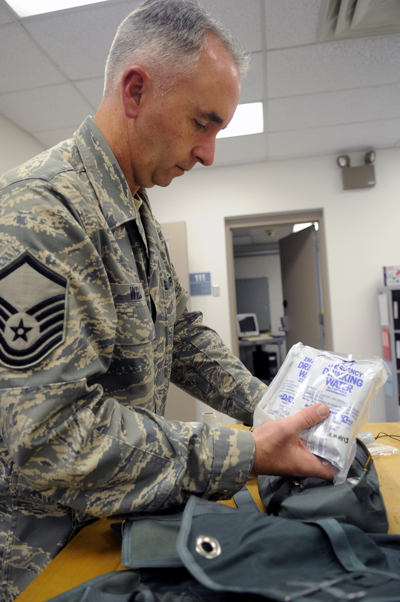 MSgt. Tim Wilson packs emergency drinking water into the survival kit that the 131st/509th Operations Group's aircrew flight equipment shop maintains on a daily basis. (Photo by Senior Airman Cory Todd/USAF 509th BW)
