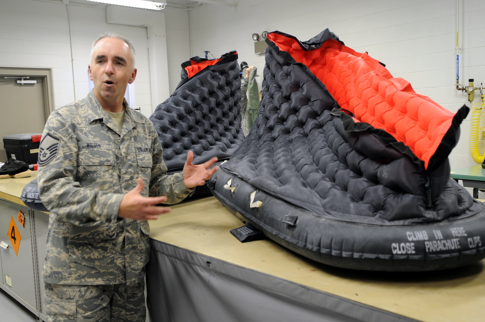 MSgt. Tim Wilson explains how pilots can use a raft to survive by staying as dry as possible and warm. (Photo by Senior Airman Cory Todd/USAF 509th BW)
