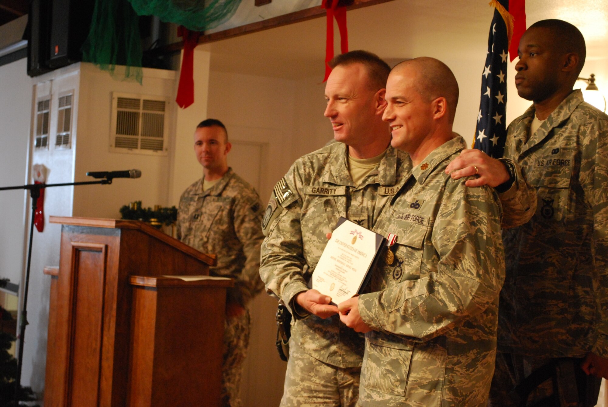 BAGRAM AIRFIELD, Afghanistan – U.S. Army Col. John F. Garrity, commander of Task Force Protector, congratulates Air Force Maj. Thomas Segars after presenting him with the Defense Meritorious Service Medal. (U.S. Army photo/Capt. Thomas Cieslak)