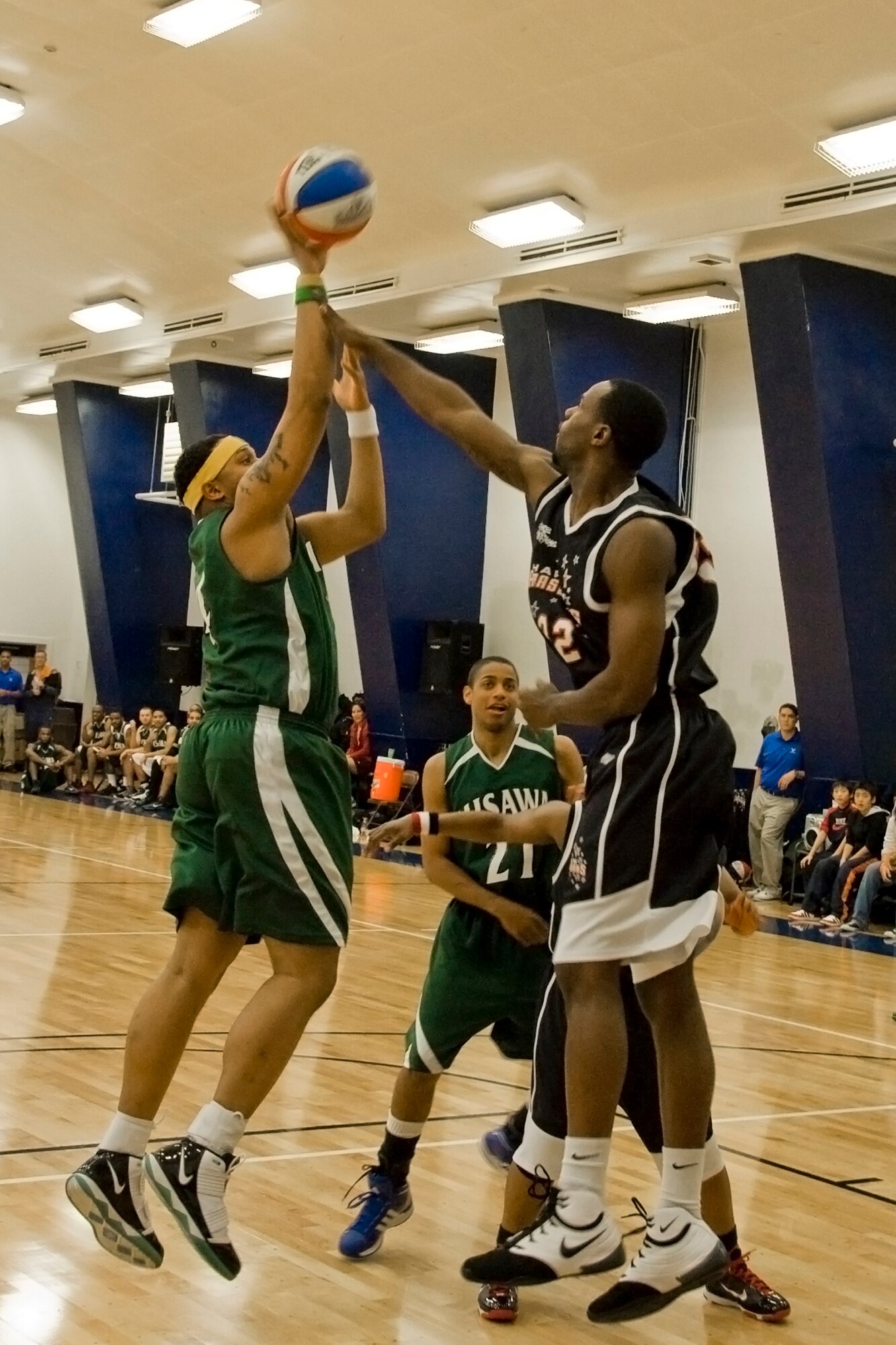 MISAWA AIR BASE, Japan -- Tauren Hunt attempts a jump shot over Sam Givens during the Misawa Jets' basketball game against the Harlem Ambassadors Dec. 7 at the Potter Fitness Center. Although competitive, the game included many comedy skits which incorporated participation from both teams and the audience. (U.S. Air Force photo/Senior Airman Jamal D. Sutter)