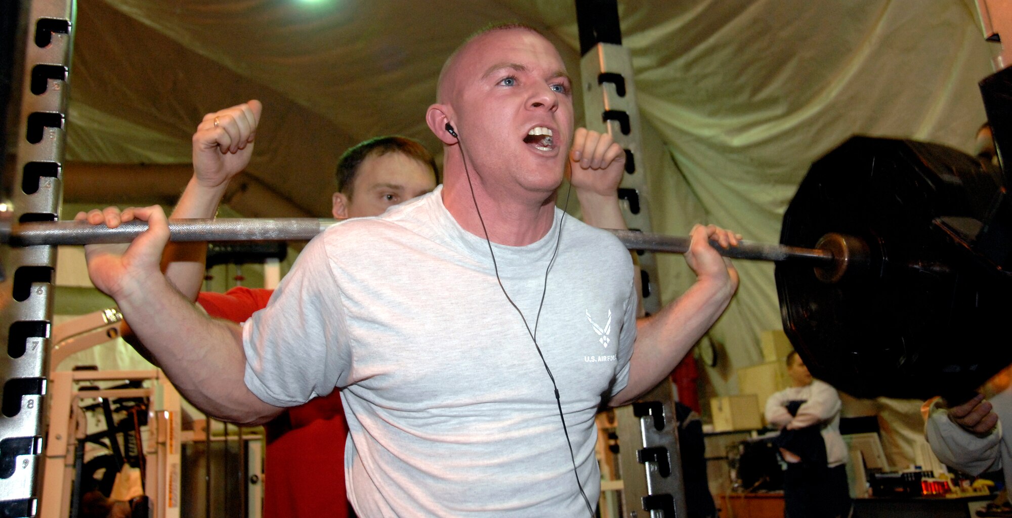 TRANSIT CENTER AT MANAS, Kyrgyzstan -- Senior Airman Mark Smith groans as he attempts to squat 475 pounds of weight during the “Strongest in the AOR” competition organized for contestants by the Fitness Center here Dec. 6.  In the combined total of bench press and squat performed, Airman Smith ranked second after Marine Sgt. Nicholas Brosko.  Airman Smith, whose combined weight lifted is 785 pounds, is assigned to the 376th Expeditionary Aircraft Maintenance Squadron here.  (U.S. Air Force photo/Staff Sgt. Olufemi Owolabi)  