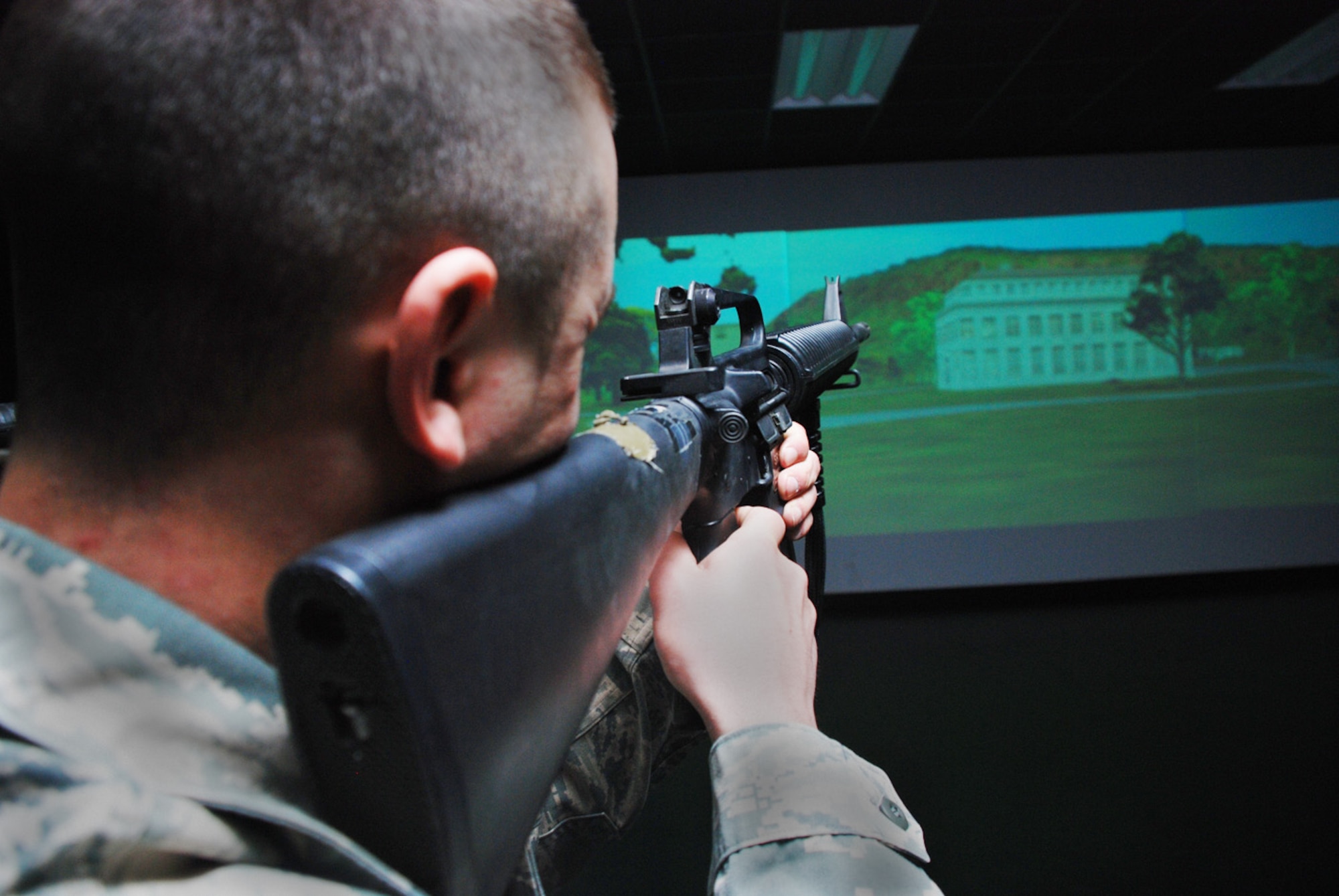 Airman 1st Class Brandon Blevins, 790th Missile Security Forces Squadron, searches for digital enemies near a building inside the base firearm training simulator March 10.