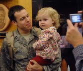 MOODY AIR FORCE BASE, Ga. -- Capt. Ben Buchta, 41st Rescue Squadron HH-60G Pave Hawk pilot, poses for a welcome home photo with his daughter Ellianna here Dec. 4. Captain Buchta is returning home from a three-month deployment to Afghanistan. (U.S. Air Force photo by Airman 1st Class Joshua Green) 