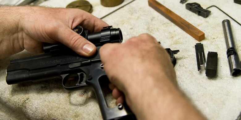 With his tools of the trade always near his side to take precision measurements and accomplish the most detailed work, William Moore can fix or refurbish just about any small arms, including this Colt 45 with a red dot optical sight (facing page) for the Air Force Shooting Team. At right is a 6-inch caliper, which provides the detail needed to ensure a gun works properly.