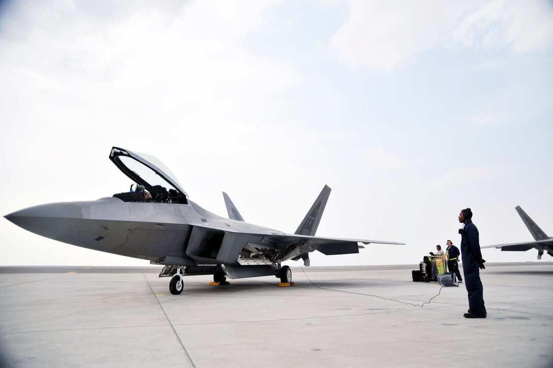 Senior Airman Deandre Barnes, 1st Fighter Wing crew chief, waits for orders as the F-22 Raptor pilot prepares for take-off Nov. 30, 2009, at an airfield in Southwest Asia.  The Airmen participated in the Iron Falcon exercise while on temporary duty from Langley Air Force Base, Va. Airman Barnes hails from Jacksonville, Ark. (U.S. Air Force photo/Tech. Sgt. Charles Larkin Sr)