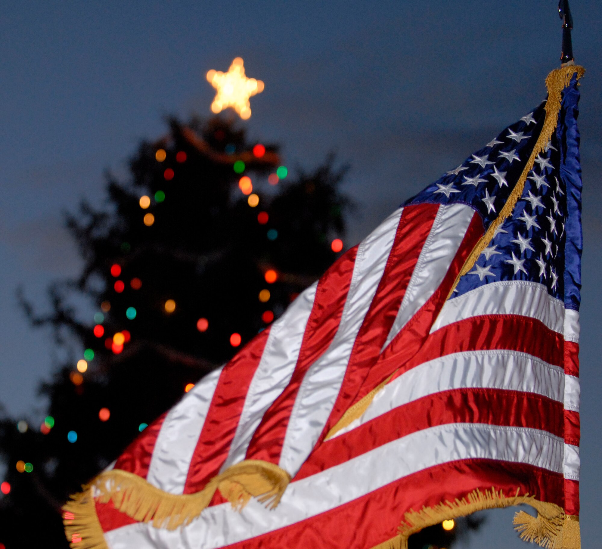 The U.S. flag waves in front of the holiday tree at the annual Dix tree lighting ceremony, Dec. 3. Nearly 100 Dixans, including servicemembers of all branches and their families, began gathering at about 4 p.m. for the traditional ceremony.  (U.S. Army photo/Spc. Spencer Case)
