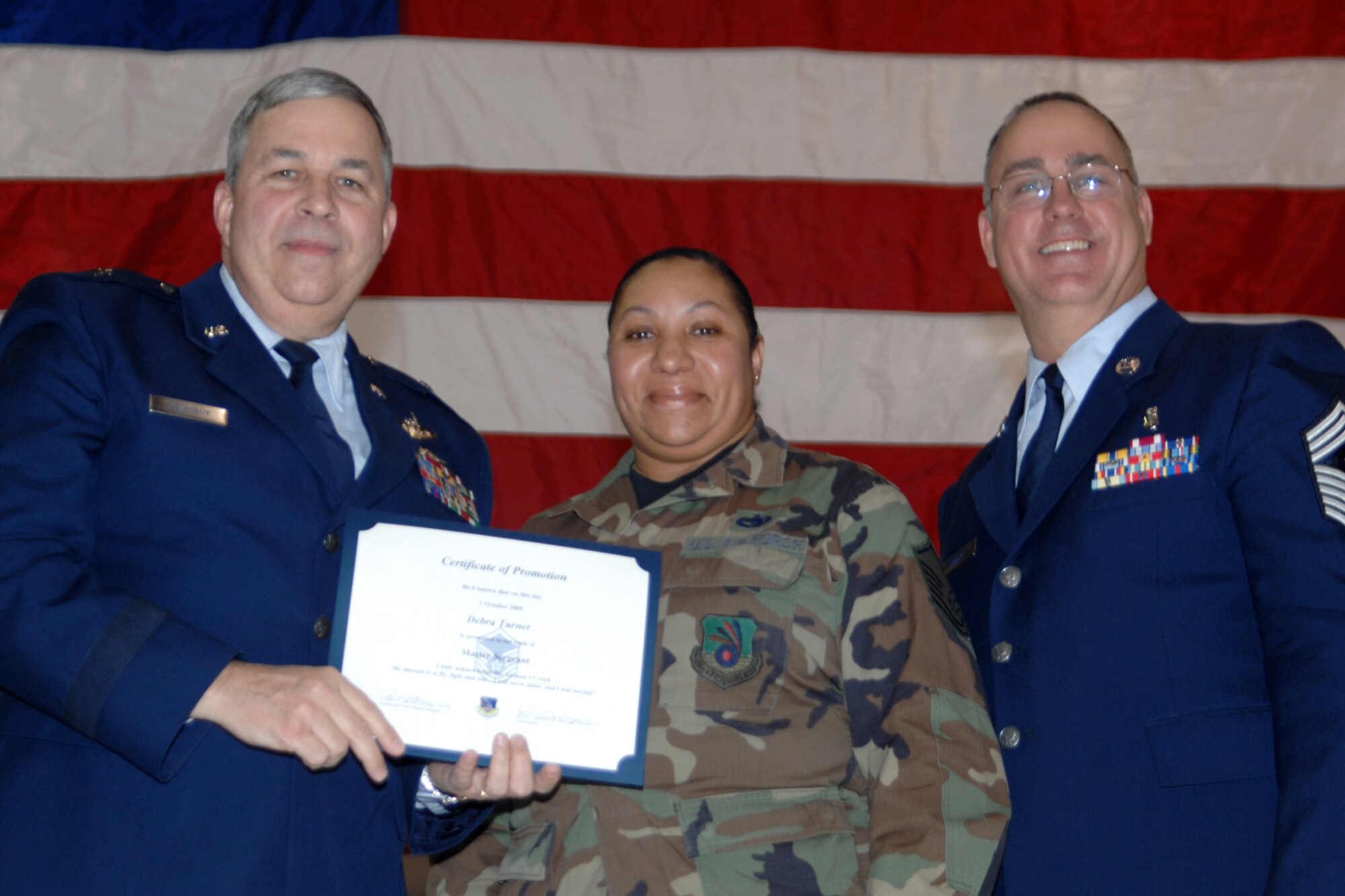 GRISSOM AIR RESERVE BASE, Ind., -- Brig. Gen. Dean Despinoy, 434th Air Refueling Wing commander, left, and Chief Master Sgt. Larry Brady, right, present a certificate to Master Sgt. Debra Turner, 49th Aerial Port Flight, recognizing her induction into the Senior NCO ranks. The presentation was made during a special ceremony recognizing recent promotees.  (U.S. Air Force photo/Tech. Sgt. Doug Hays)