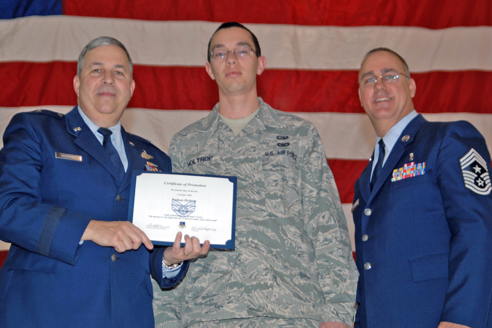 GRISSOM AIR RESERVE BASE, Ind., -- Brig. Gen. Dean Despinoy, 434th Air Refueling Wing commander, left, and Chief Master Sgt. Larry Brady, right, present a certificate to Staff Sgt. Nathan Holtrop, a computer systems operator with the 434th Communications Squadron, recognizing his induction into the NCO ranks. (U.S. Air Force photo/Tech. Sgt. Doug Hays)