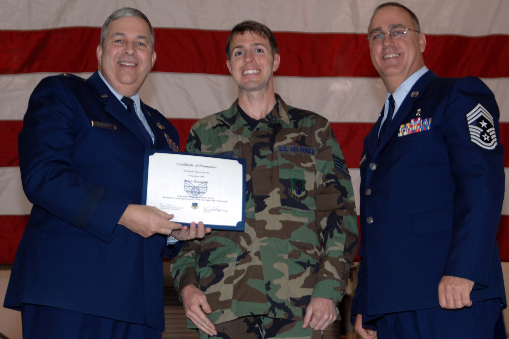 GRISSOM AIR RESERVE BASE, Ind., -- Brig. Gen. Dean Despinoy, 434th Air Refueling Wing commander, left, and Chief Master Sgt. Larry Brady, right, present a certificate to Staff Sgt. Brian Baumfalk, a KC-135 Stratotanker crew chief with the 434th Maintenance Squadron, recognizing his induction into the NCO ranks. The presentation was made during a special ceremony held at Grissom. (U.S. Air Force photo/Tech. Sgt. Doug Hays)