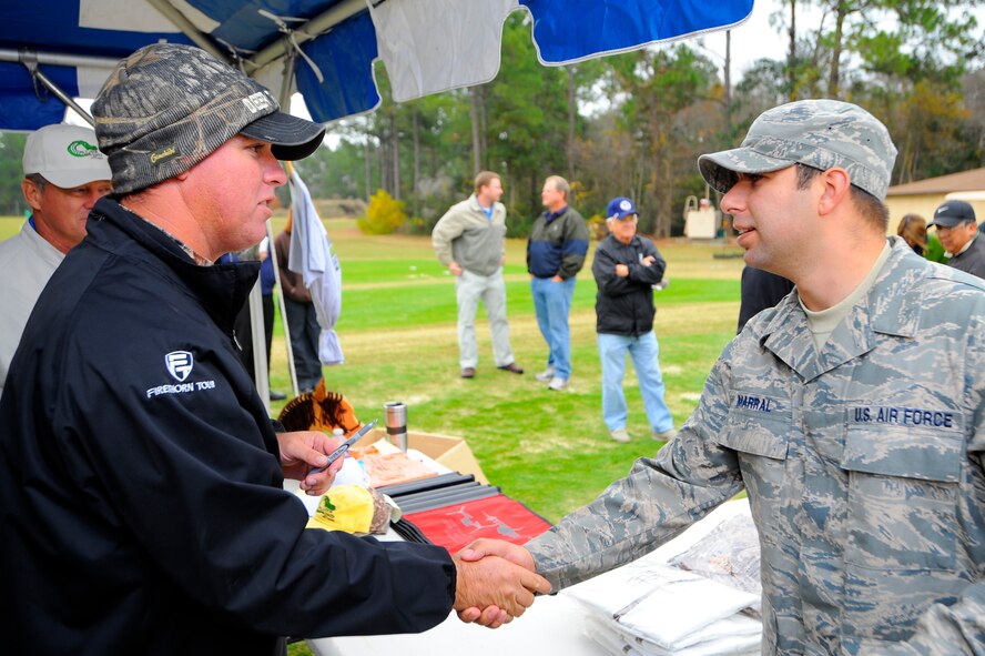 Professional golfer Boo Weekley shakes the hand of Senior Airman Todd Marral, 1st Special Operations Communications Squadron, at the Gator Lakes golf course at Hurlburt Field Dec. 3. Mr. Weekley took time to pose for pictures, autograph golf balls and answer questions for servicemembers and their families at the event.  (Air Force photo by Senior Airman Jason Epley)