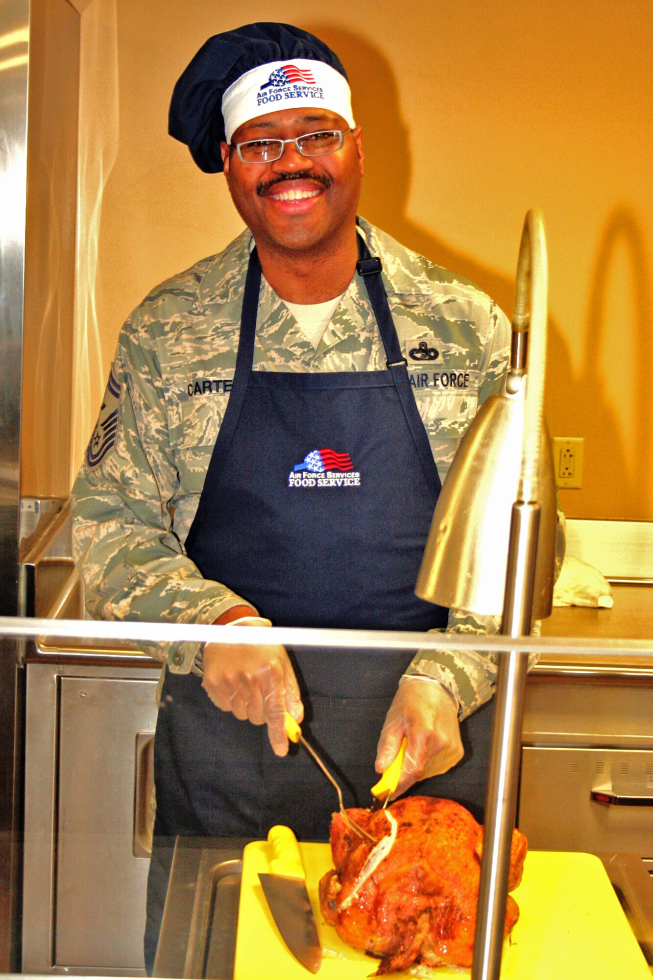 GRISSOM AIR RESERVE BASE, Ind., -- Senior Master Sgt. James Carter, 434th Maintenance Squadron first sergeant, carves a turkey for the Christmas meal served Dec. 5 at the dining facility. Grissom commander's, chiefs and first sergeants served the meal to Airmen of the 434th ARW during lunch.  (U.S. Air Force photo/Staff Sgt. Chris Bolen)