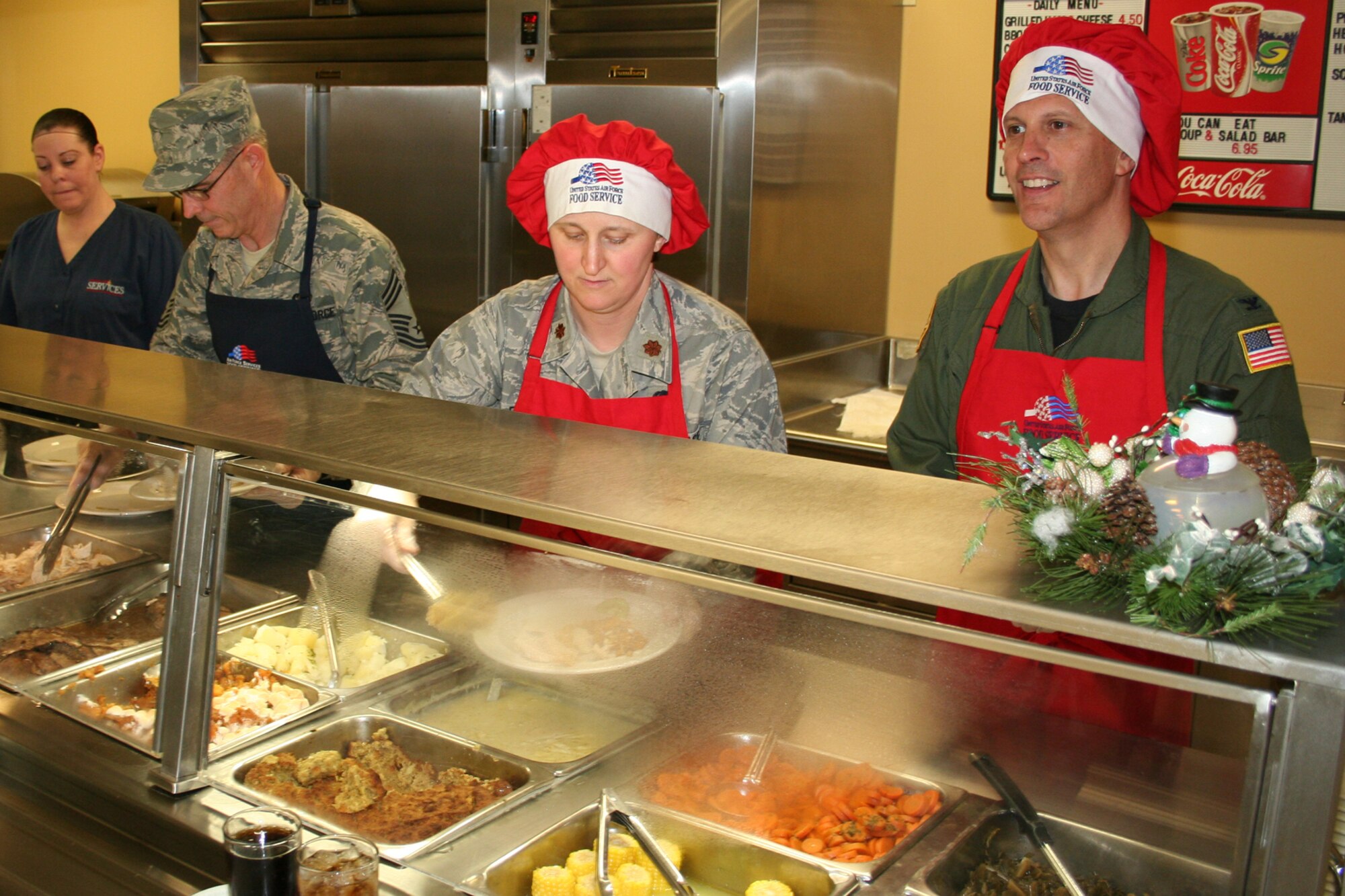 GRISSOM AIR RESERVE BASE, Ind., -- From left, Chief Master Sgt. David Sward, 434th Aircraft Maintenance Squadron, Maj. Becky Fox, 434th Communications Squadron commander, and Col. Randy Ogden, 434th Operations Group commander, dish out a holiday meal during the December unit training assembly.  Grissom commander's, chiefs and first sergeants served the meal to Airmen of the 434th ARW during lunch.  (U.S. Air Force photo/Staff Sgt. Chris Bolen)