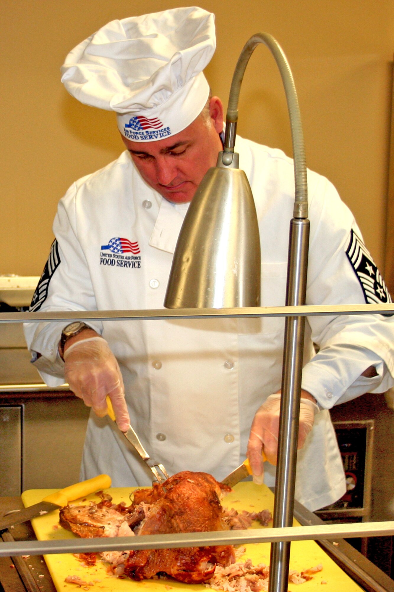 GRISSOM AIR RESERVE BASE, Ind., -- Chief Master Sgt. Larry Brady, 434th Air Refueling Wing command chief, carves a turkey for the Christmas meal served at the dining facility. Grissom commander's, chiefs and first sergeants served the meal to Airmen of the 434th ARW during lunch.  (U.S. Air Force photo/Staff Sgt. Chris Bolen)
