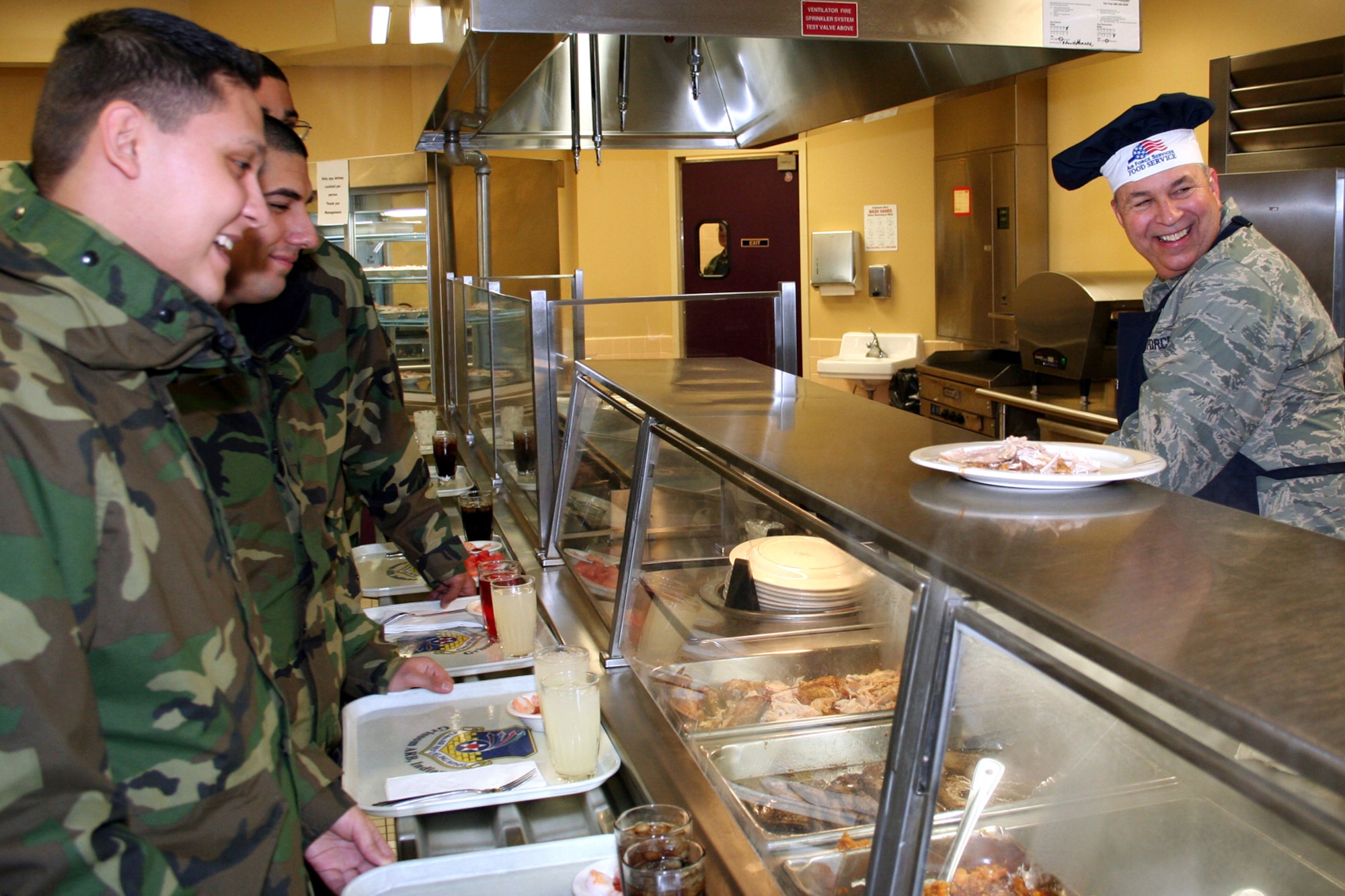 GRISSOM AIR RESERVE BASE, Ind., -- Brig Gen. Dean Despinoy, 434th Air Refueling Wing commander, right, is all smiles as he prepares  a plate while serving  Christmas dinner to Grissom Airmen during the December UTA.  (U.S. Air Force photo/Staff Sgt. Chris Bolen)