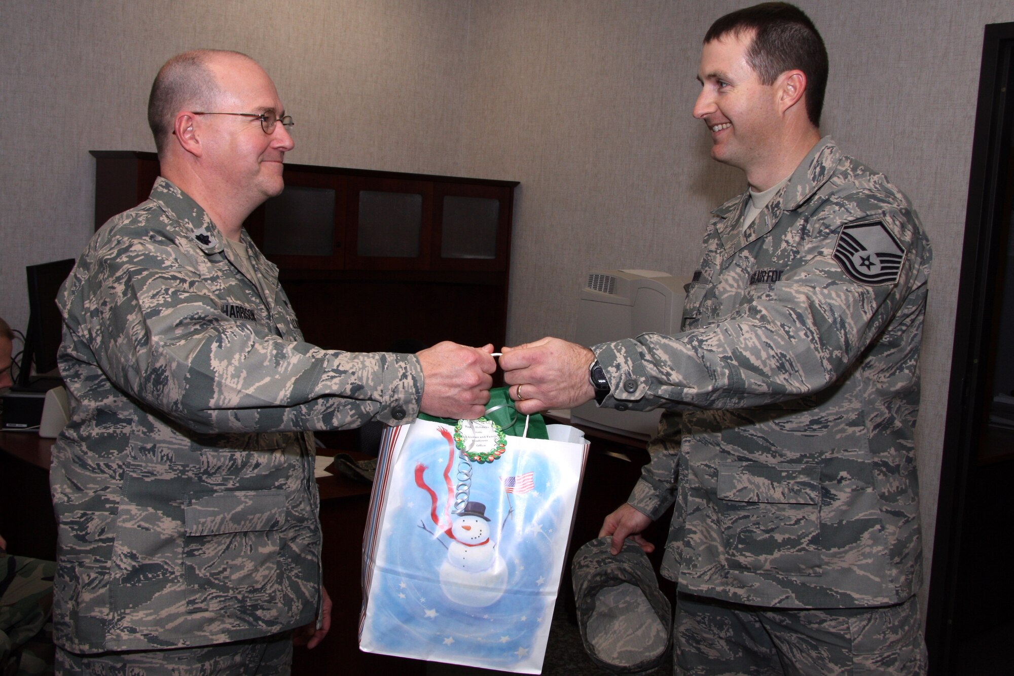 GRISSOM AIR RESERVE BASE, Ind. -- Lt. Col. Daniel Harrison, 434th Mission Support Flight commander, accepts a holiday bag full of candy canes from Master Sgt. Nathan Moore, 434th Airman and Family Readiness noncommissioned officer in charge. The Airman and Family Readiness office here gave out these holiday packages to each unit in celebration of the holiday season during the December unit training assembly. (U.S. Air Force photo/Tech. Sgt. Mark Orders-Woempner)