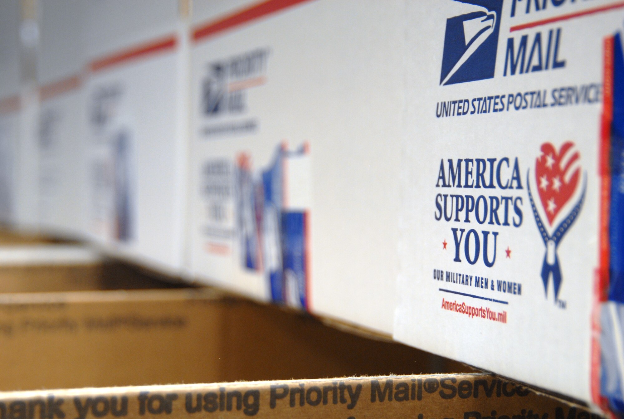 Stacks of boxes full of care package items await to be shipped to deployed Airmen as part of  Operation Touch Our Warriors. The program aims to provide donated gifts to Edwards Airmen who are deployed during the holiday season. Edwards leadership volunteered to pack the care packages Dec. 4 at the First Term Airman Center classroom. (U.S. Air Force photo/Senior Airman Julius Delos Reyes)