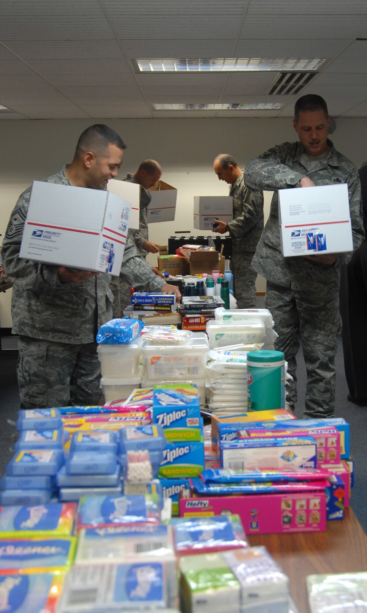 Volunteers pack care package boxes Dec. 4 at the First Term Airman Center classroom. This was part of Operation Touch Our Warriors, which aims to provide donated gifts to Edwards Airmen who are deployed during the holiday season. (U.S. Air Force photo/Senior Airman Julius Delos Reyes)