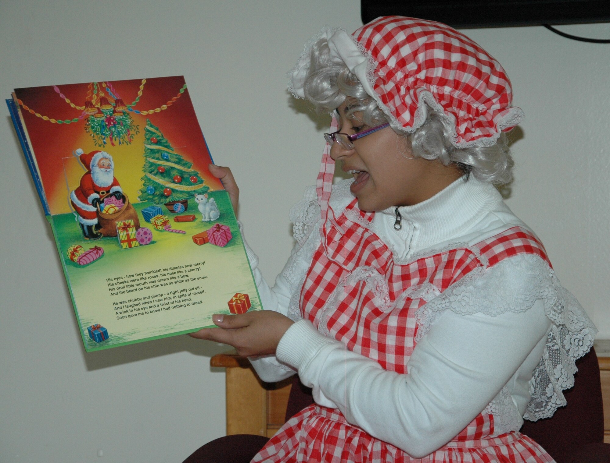“Mrs. Claus,” Senior Airman Millie Roldan, reads to children during Give a Child a Christmas Dec. 5 at Eglin's Youth Center. The volunteer from the 46th Aircraft Maintenance Squadron was one of approximately 300 people that helped in some way to bring holiday cheer to 150 needy children from the local area.