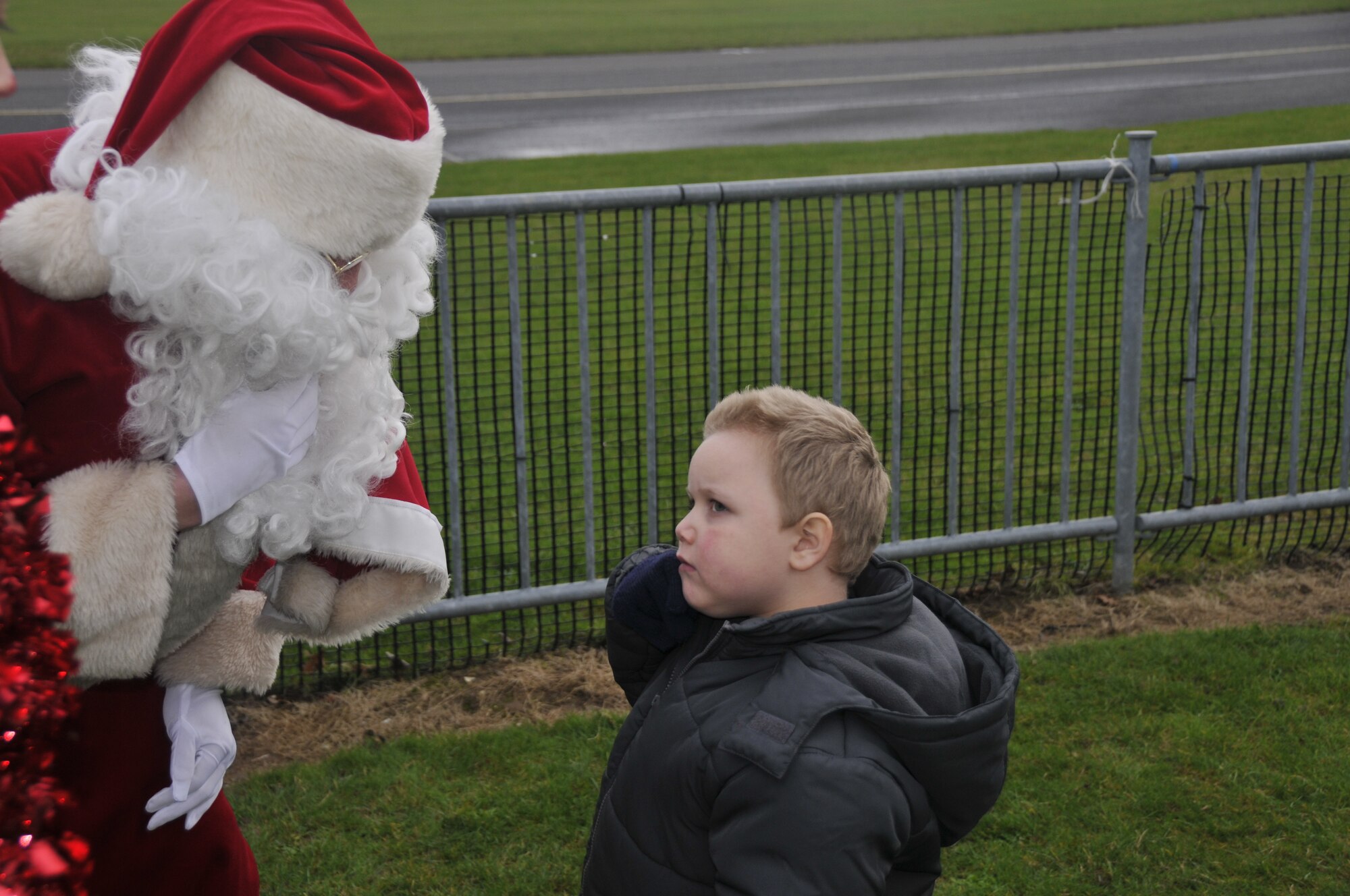 A young boy at the Imperial War Museum at Duxford asks Santa Claus where his reindeer and sleigh are on Dec. 5. Santa let him know the sleigh was in the shop for repairs and the U.S. Air Force was nice enough to give him a lift to the party. Volunteers from the 48th Fighter Wing hosted a party for terminally and seriously ill children at the museum. (Photo by Tech. Sgt. Chris Stagner)