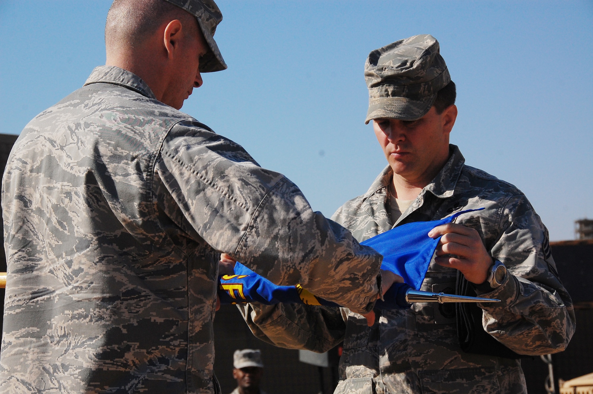 Maj. Larry Woodleft and Chief Master Sgt. James Johnson furl the 887th ESFS guidon during the squadron's deactivation ceremony Dec. 3, 2009 at Camp Bucca, Iraq. Major Woodleft is the 887th Expeditionary Security Forces Squadron commander. (U.S. Air Force photo/Staff Sgt. Shaun Emery)
