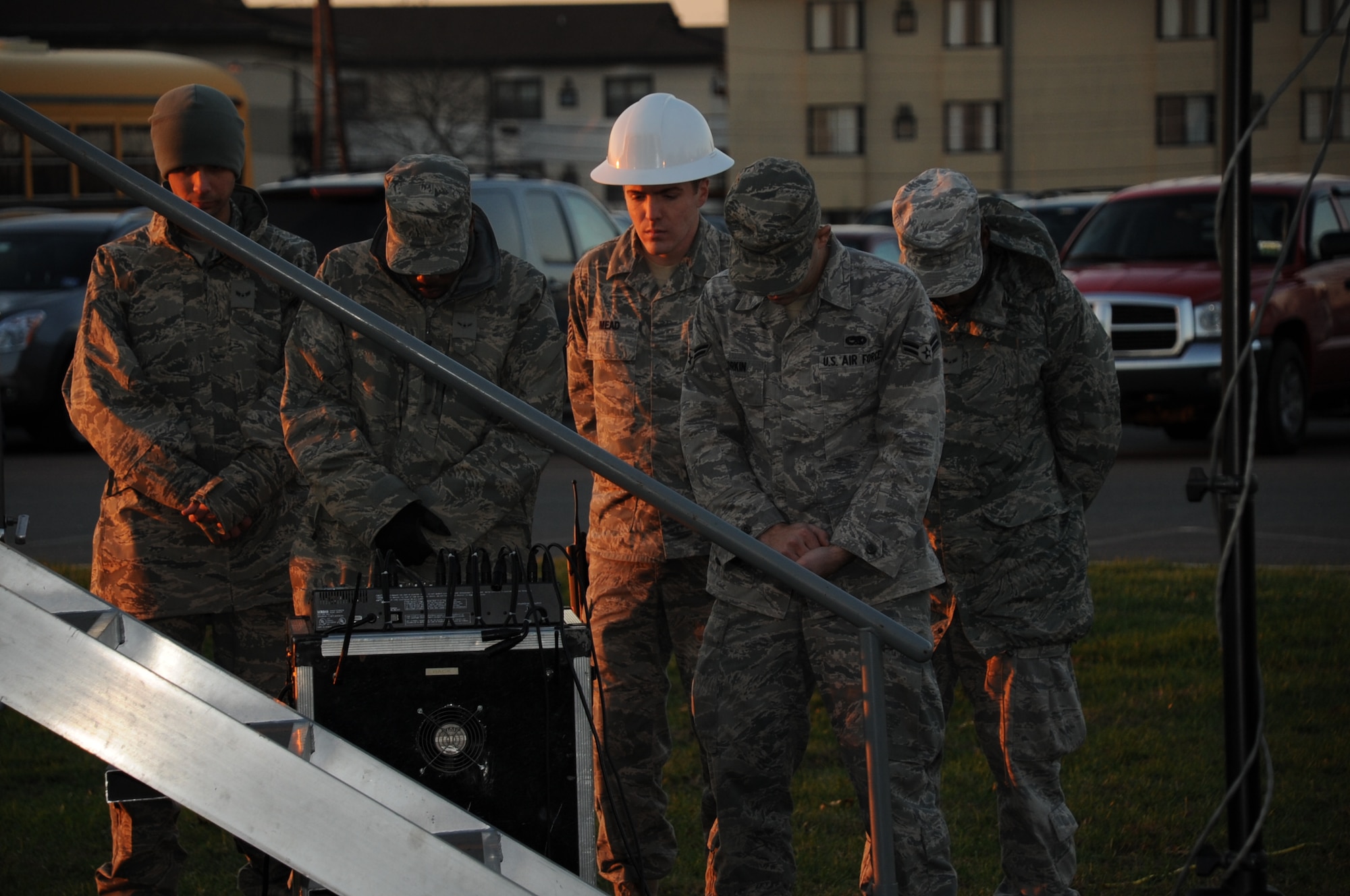 Airmen from the 87th Civil Engineering Squadron lower their heads during the "Prayer for the Nation" invocation, administered by Chaplain (Lt. Col.) Joseph Lim, at the McGuire tree lighting ceremony, Dec. 1. "We thank you for this time of fun and fellowship that we take part in tonight and for the true meaning of the Holiday Season," said Chaplain Lim. (U.S. Air Force Photo/ Pascual Flores) 