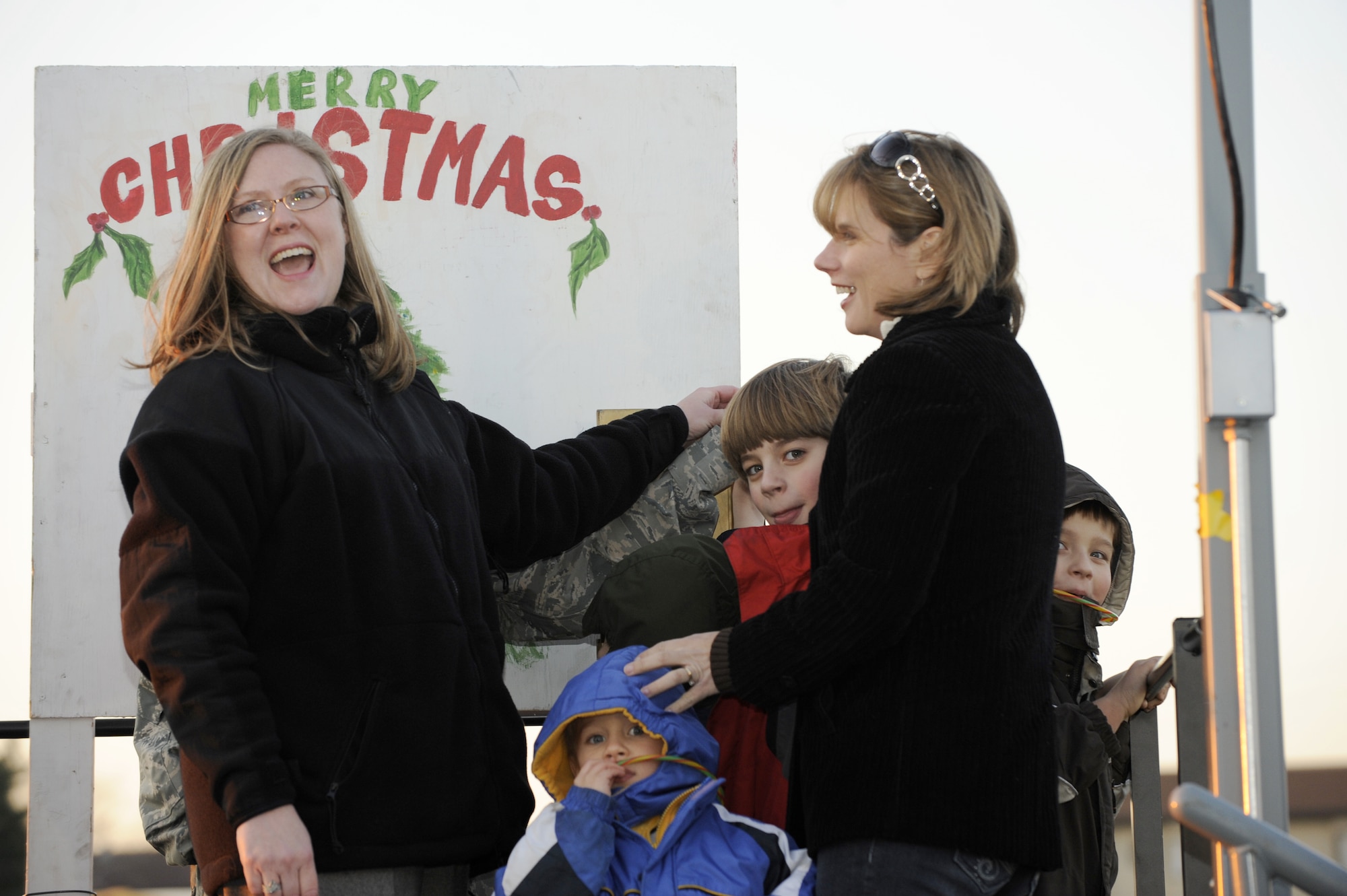 Tree lighting guests of honor, Kim Curtis and children and Melodye Schobert and son, prepare to throw the switch that would lights this year's holiday tree in front of  Chapel One on McGuire, Dec. 1. Winners of the holiday card contest were announced after the tree was lit. (U.S. Air Force Photo/Carlos Cintron)