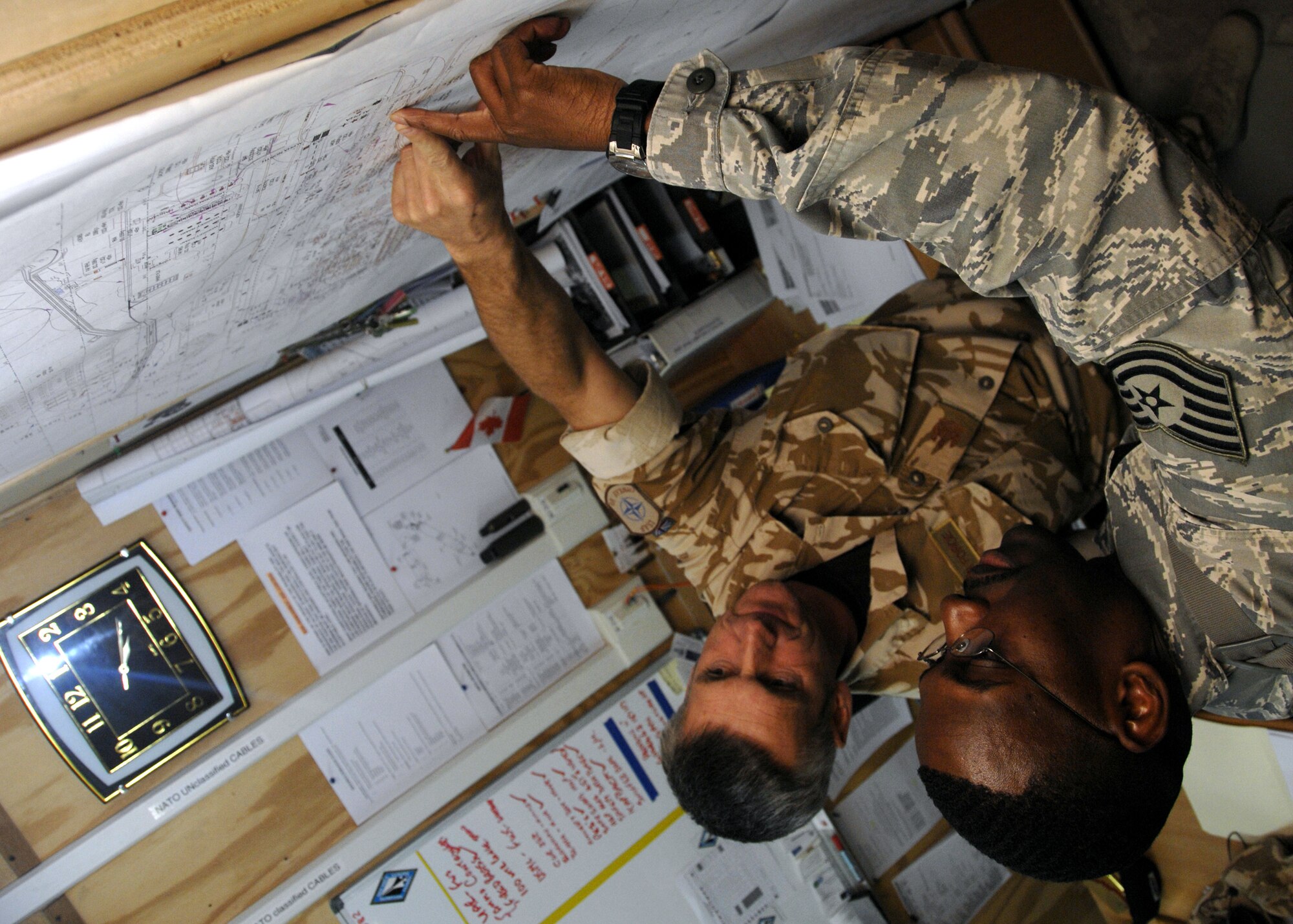 KANDAHAR AIRFIELD, Afghanistan -- Tech. Sgt. Anthony Moore and British Warrant Officer Neil Baum monitor control construction and facility utilization inside explosives clear zones here Dec. 3, 2009.  The management of explosives safety clear zones is a cornerstone of the explosives site planning process. Sergeant Moore is a Weapons Safety Manager for the 451st Safety Office from Langley Air Force Base, Va. (U.S. Air Force photo/Senior Airman Timothy Taylor) 