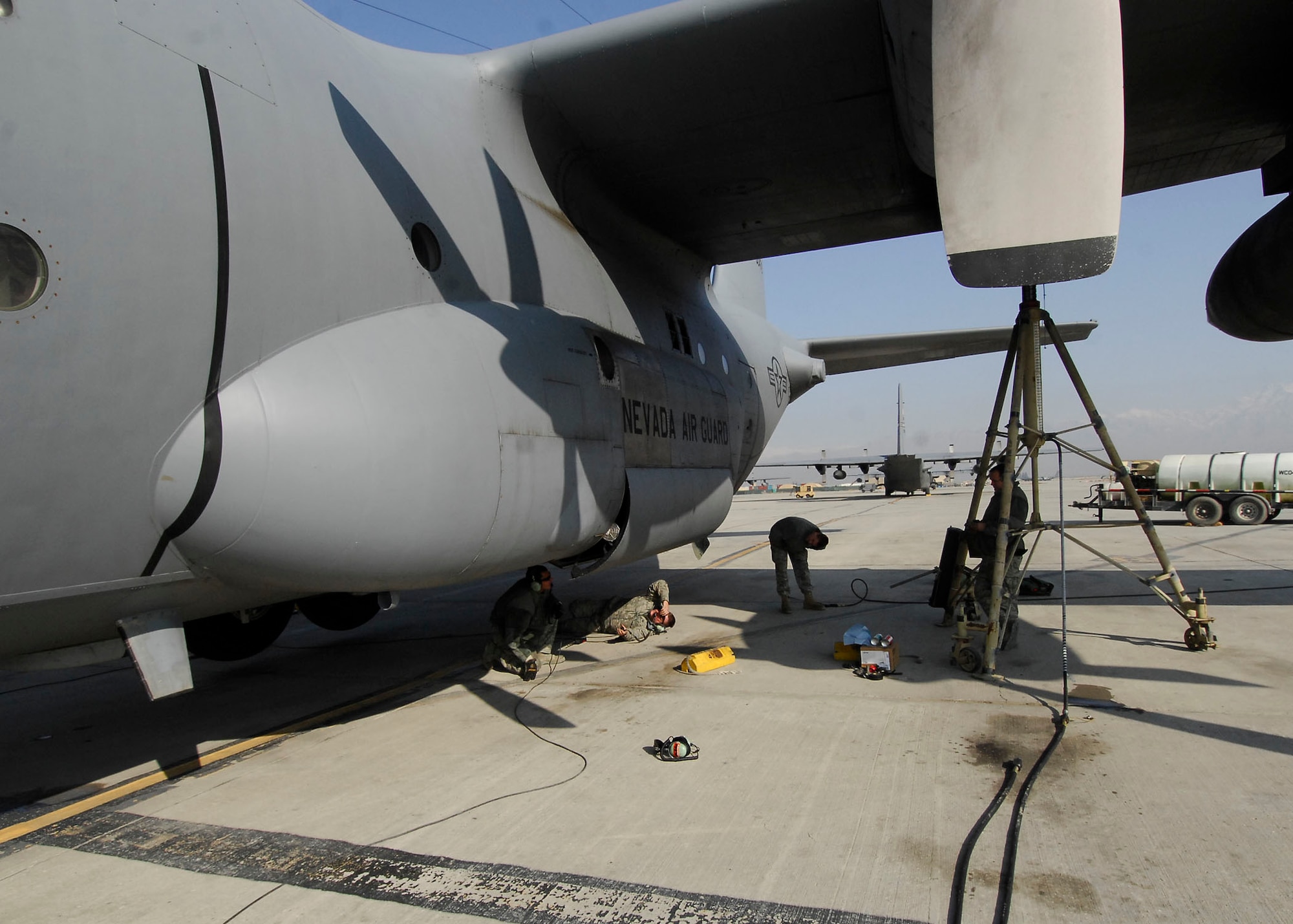 BAGRAM AIRFIELD, Afghanistan -- Crew chiefs from the 455th Expeditionary Aircraft Maintenance Squadron ensure the landing gear is working properly after performing maintenance on the C-130 Hercules, Dec. 7, 2009.  During an inspection on the aircraft the Airmen found a problem with the landing gear which they immediately fixed to keep the aircraft on time for future missions.  The Airmen are deployed from the Nevada Air National Guard's 152nd Airlift Wing.  (U.S. Air Force photo/Senior Airman Felicia Juenke)