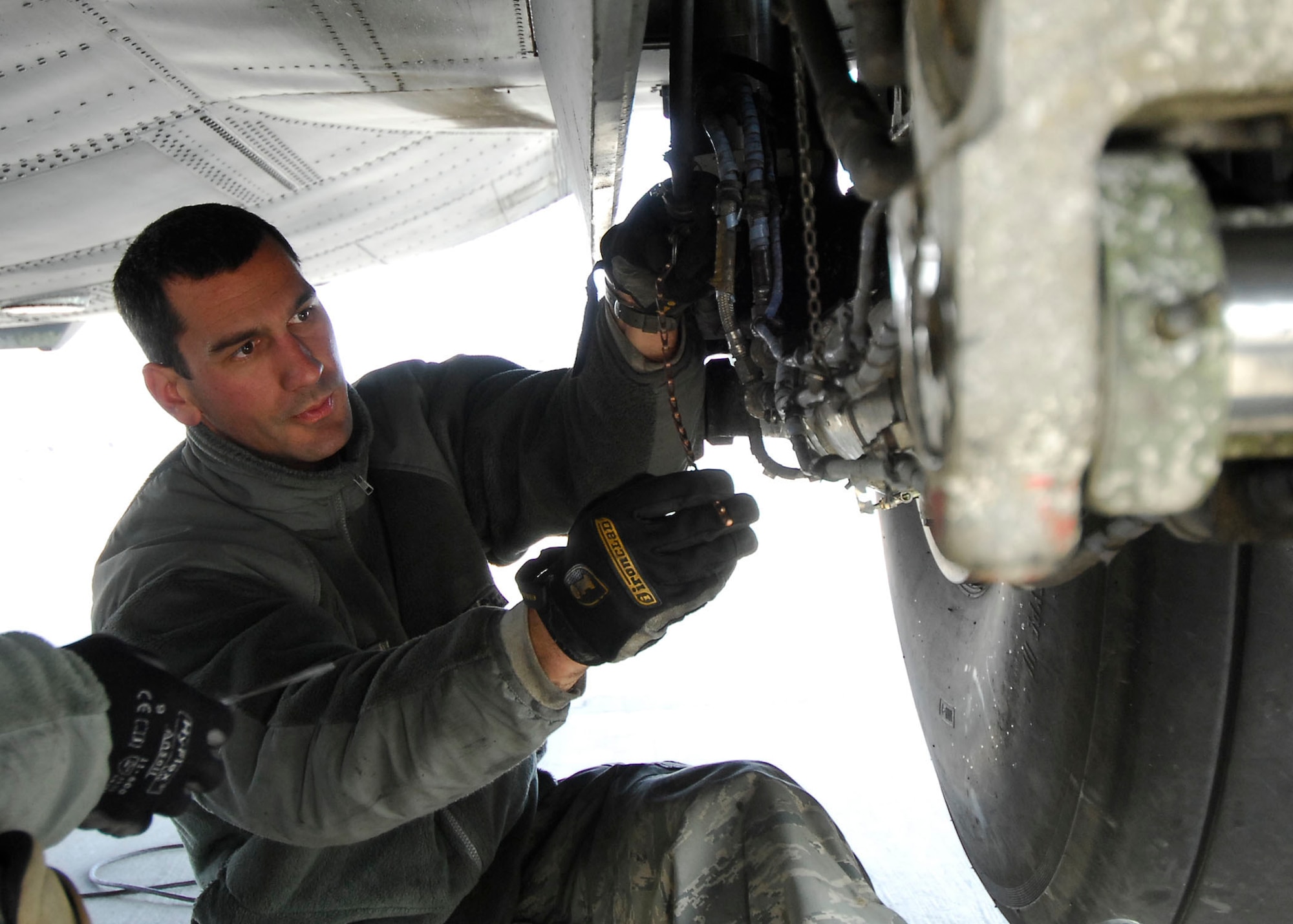 BAGRAM AIRFIELD, Afghanistan -- Tech. Sgt. Mike Smith performs landing gear maintenance on a C-130 Hercules, Dec. 7, 2009.  During an inspection on the aircraft the Airmen found a problem with the landing gear which they immediately fixed to keep the aircraft on time for future missions.  Sergeant Smith, a crew chief from the 455th Expeditionary Aircraft Maintenance Squadron, is deployed from the Nevada Air National Guard's 152nd Airlift Wing and hails from Reno, Nev.  (U.S. Air Force photo/Senior Airman Felicia Juenke)