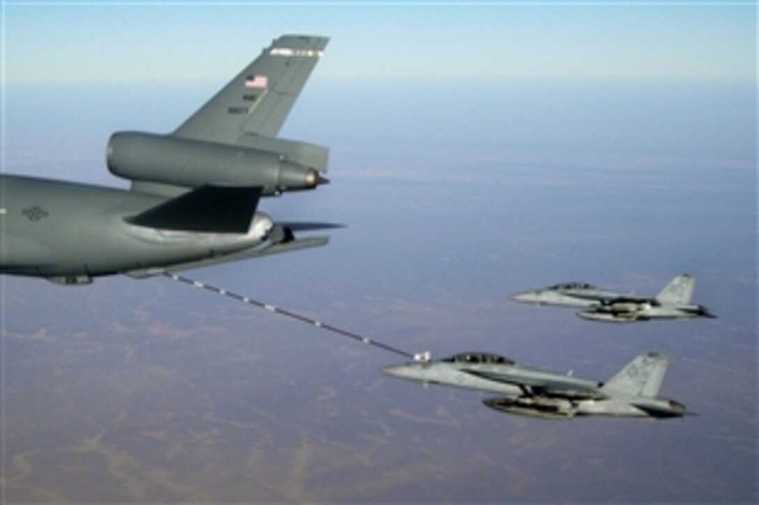U.S. Navy F/A-18F Super Hornets assigned to Strike Fighter Squadron 41, embarked aboard the aircraft carrier USS Nimitz, refuel from an Air Force KC-10 Extender while an F/A-18E Super Hornet flies starboard observation position on station over Afghanistan, Dec. 5, 2009. The strike fighter squadrons are part of the Nimitz Carrier Strike Group on a deployment to the region.

