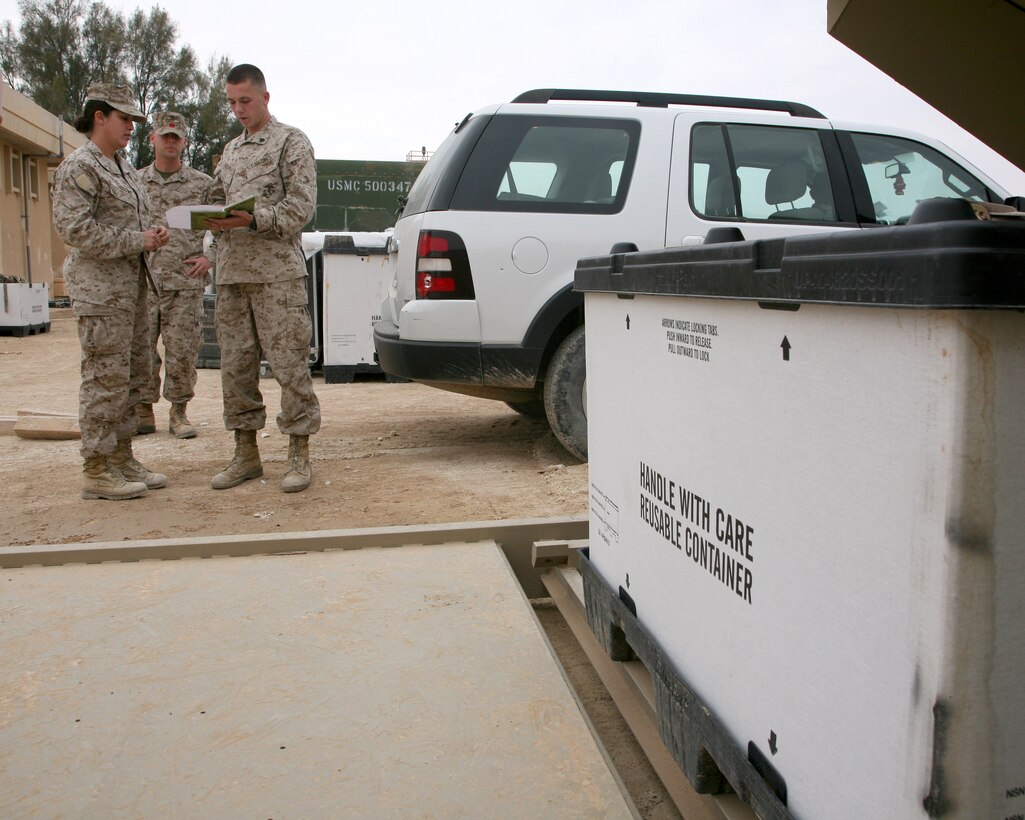 Chief Warrant Officer 2 Dawn Sprowl (left), the embark officer for II Marine Expeditionary Force Headquarters Group (Forward), goes over paperwork with Sgt. Jimmy Young, an embark clerk, aboard Al Asad Air Base, Iraq, Dec. 8, 2009.  The embark office is responsible for moving II MEF (Fwd) personnel and gear into, around and out of Iraq.