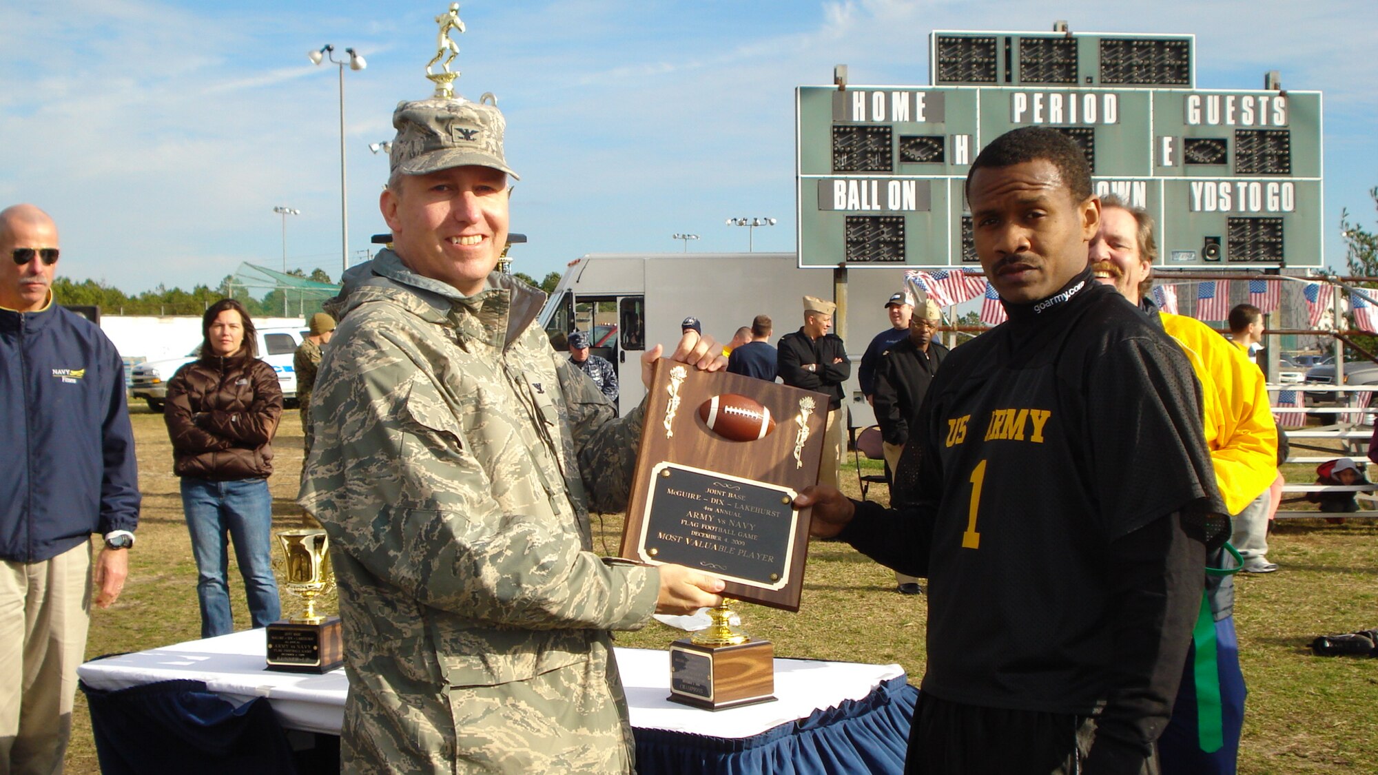 Colonel Michael Carrell, 87th Mission Support Group commander, presents the winning plaque to Staff Sgt.Terrence Garrett, the Army team's most valuable player, after the Army vs. Navy flag football game on Lakehurst Dec. 4. The Army won the game 6-0. (courtesy photo)

