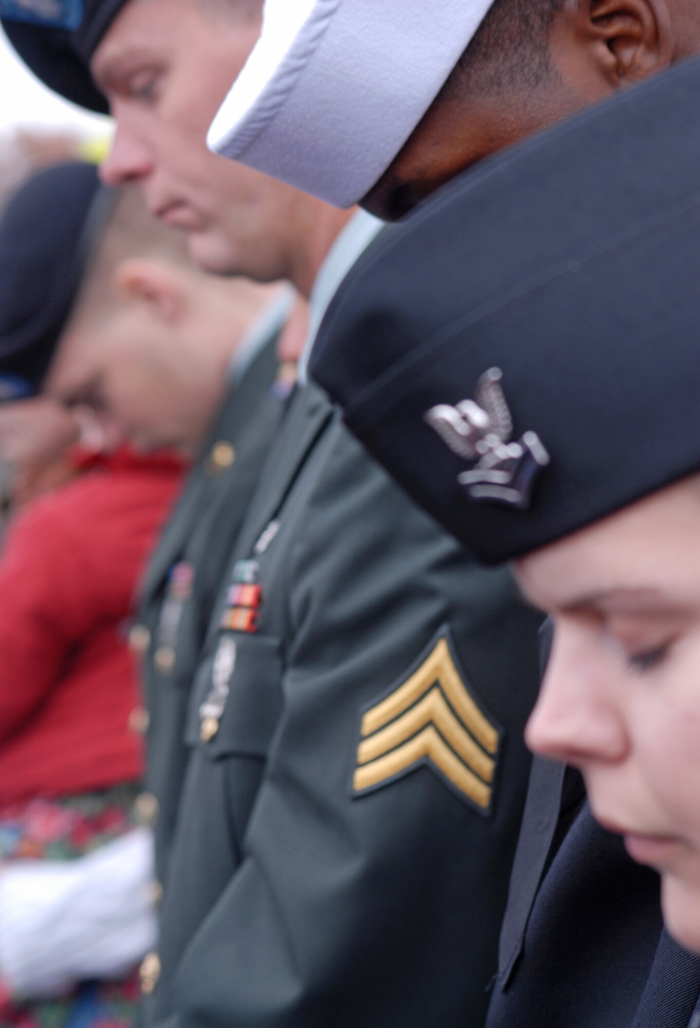 Navy Petty Officer 2nd Class Rebecca Parrish and other service members from Goodfellow AFB, Texas, bow their heads for the invocation before the grand opening ceremony of the George H.W. Bush Gallery of the War in the Pacific Museum, Fredericksburg on Dec. 7.  80 volunteers of Soldiers, Sailors, Airman and Marines from Goodfellow travelled 150 miles to help with the opening of the museum expansion, providing chair set-up and tear down, distinguished guests escort and led tours of the new facility.  The former President George H.W. Bush, attended as well as Rick Perry, Governor of Texas.  Over 4,000 people were in attendance.  (U.S. Air Force photo by/Robert D. Martinez)