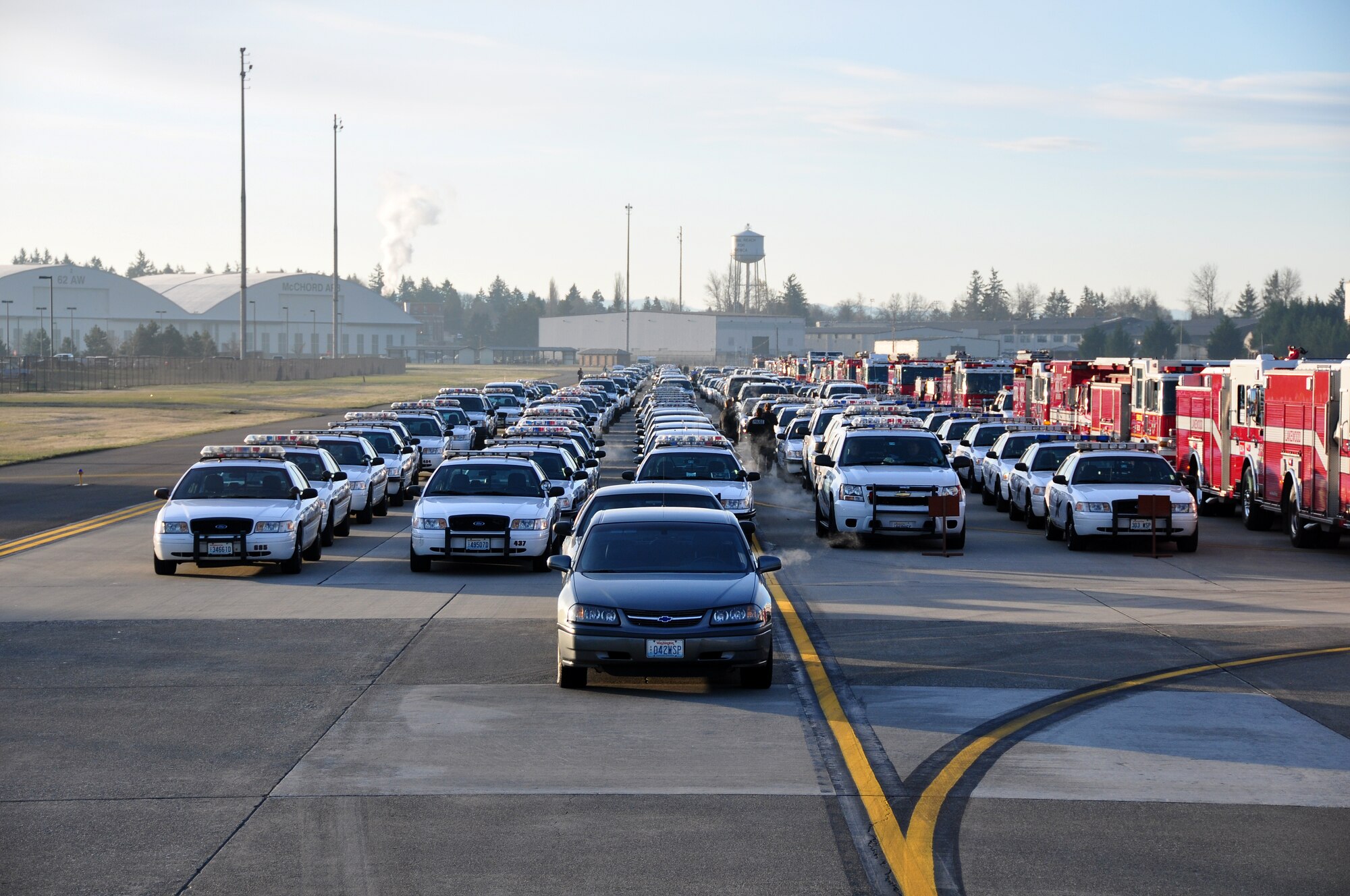 Approximately 2,000 emergency services vehicles from throughout the U.S. and Canada depart McChord Air Force Base Dec. 8 in a procession to the Tacoma Dome Memorial Service honoring four fallen Lakewood, Wash., Police Officers.  McChord Airmen provided a staging area for emergency responders and their vehicles and honored the Lakewood Police Officers by lining the streets of the installation procession route. (U.S. Air Force Photo/Staff Sgt. Robert Tingle)