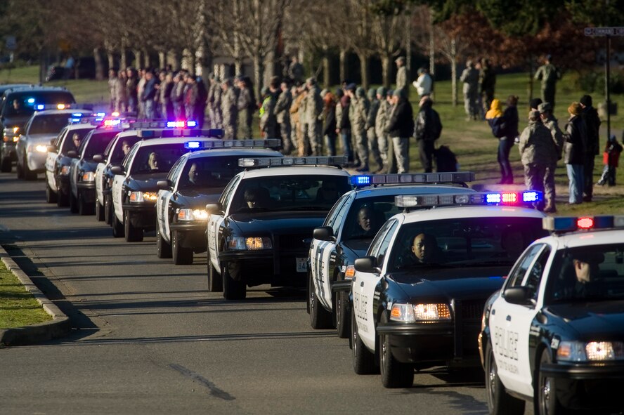 Approximately 2,000 emergency services vehicles from throughout the U.S. and Canada depart McChord Air Force Base Dec. 8 in a procession to the Tacoma Dome Memorial Service honoring four fallen Lakewood, Wash., Police Officers.  McChord Airmen provided a staging area for emergency responders and their vehicles and honored the Lakewood Police Officers by lining the streets of the installation procession route. (U.S. Air Force Photo/Abner Guzman)