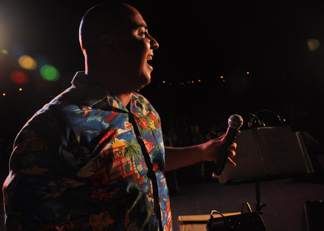 HICKAM AIR FORCE BASE, Hawaii -- Staff Sgt. Richard Vasquez, a vocalist with Hana Hou, U.S. Air Force Band of the Pacific - Hawaii, sings Chirstmas carols during a performance Dec. 4 at the Freedom Tower Lighting celebration. More than 5,000 multi-colored twinkle lights make the tower Oahu's largest Christmas tree at 171 feet tall. This year marked the 40th anniversary of the freedom tower lighting. Hickam's history reports that it was spared from the Japanese attack on Dec. 7, 1941 because they believed the majestic tower was our place of worship. The tower stored 500,000 gallons of emergency water for the base. (U.S. Air Force photo/Staff Sgt. Mike Meares)