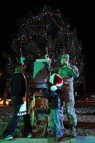NELLIS AIR FORCE BASE, Nev. - Col. Dave Belote 99th Air Base Wing, commander and two children from the crowd flip the switch turning on the base Christmas tree lights during Nellis's annual Menorah and Christmas tree lighting ceremony at the Base Chapel Dec. 4.  Airman and their Families  gathered outside the chapel to sing Christmas carols, meet Santa Claus, and celebrate the holiday season.(U.S. Air Force photo by Tech. Sgt. Michael R. Holzworth)