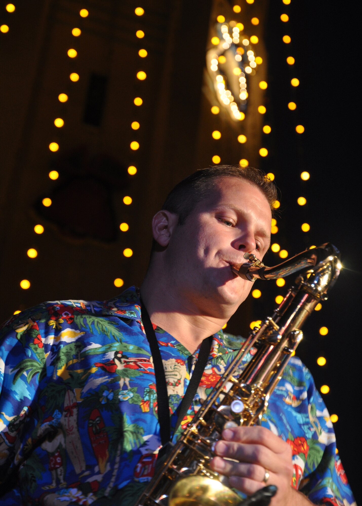 HICKAM AIR FORCE BASE, Hawaii -- Tech. Sgt. Joshua Fedele, a musician with Hana Hou, U.S. Air Force Band of the Pacific - Hawaii, performs holiday music during the Freedom Tower Lighting celebration Dec. 4. More than 5,000 multi-colored twinkle lights make the tower Oahu's largest Christmas tree at 171 feet tall. This year marked the 40th anniversary of the freedom tower lighting. Hickam's history reports that it was spared from the Japanese attack on Dec. 7, 1941 because they believed the majestic tower was our place of worship. The tower stored 500,000 gallons of emergency water for the base. (U.S. Air Force photo/Staff Sgt. Mike Meares)
