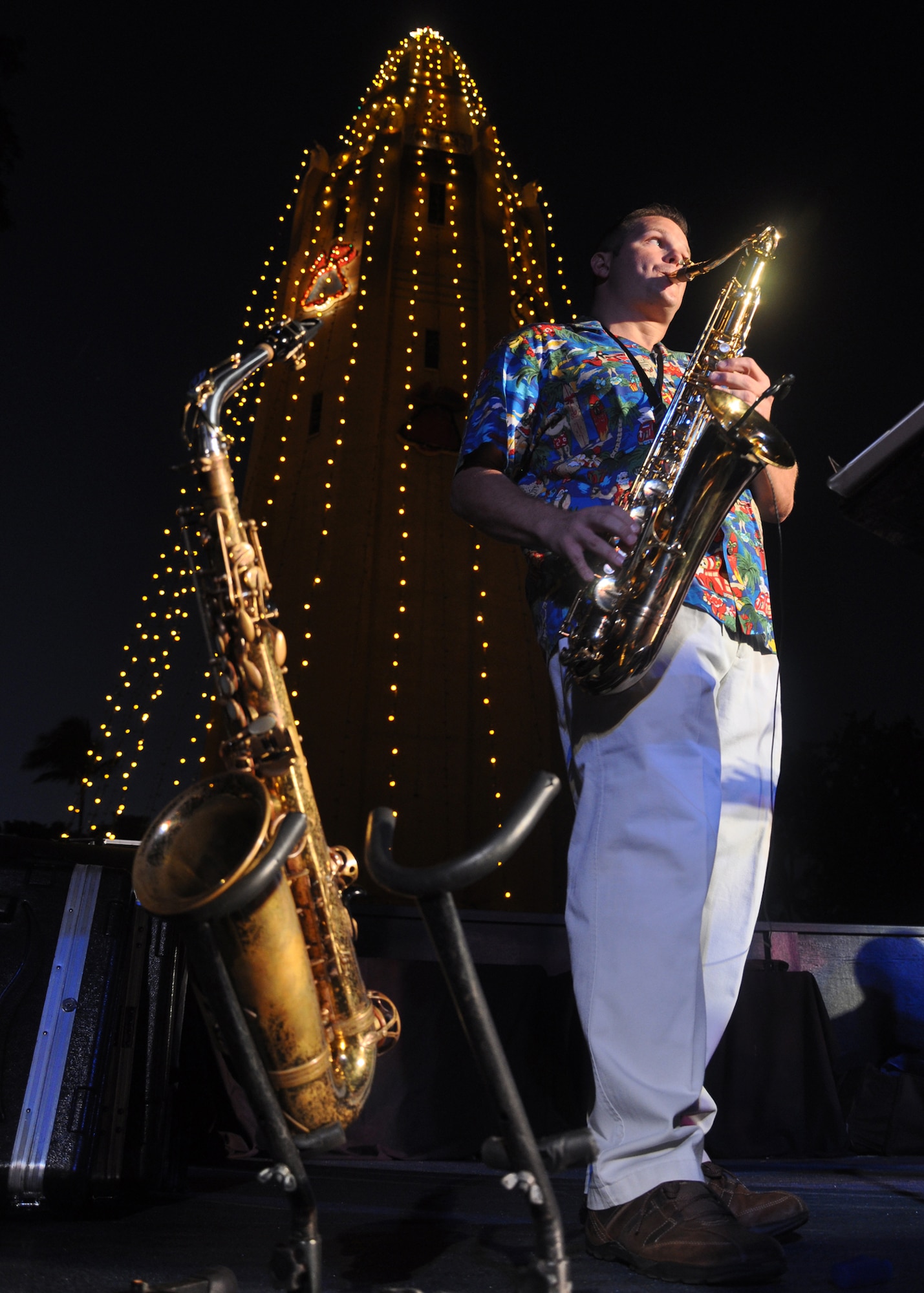 HICKAM AIR FORCE BASE, Hawaii -- Tech. Sgt. Joshua Fedele, a musician with Hana Hou, U.S. Air Force Band of the Pacific - Hawaii, performs holiday music during the Freedom Tower Lighting celebration Dec. 4. More than 5,000 multi-colored twinkle lights make the tower Oahu's largest Christmas tree at 171 feet tall. This year marked the 40th anniversary of the freedom tower lighting. Hickam's history reports that it was spared from the Japanese attack on Dec. 7, 1941 because they believed the majestic tower was our place of worship. The tower stored 500,000 gallons of emergency water for the base. (U.S. Air Force photo/Staff Sgt. Mike Meares)