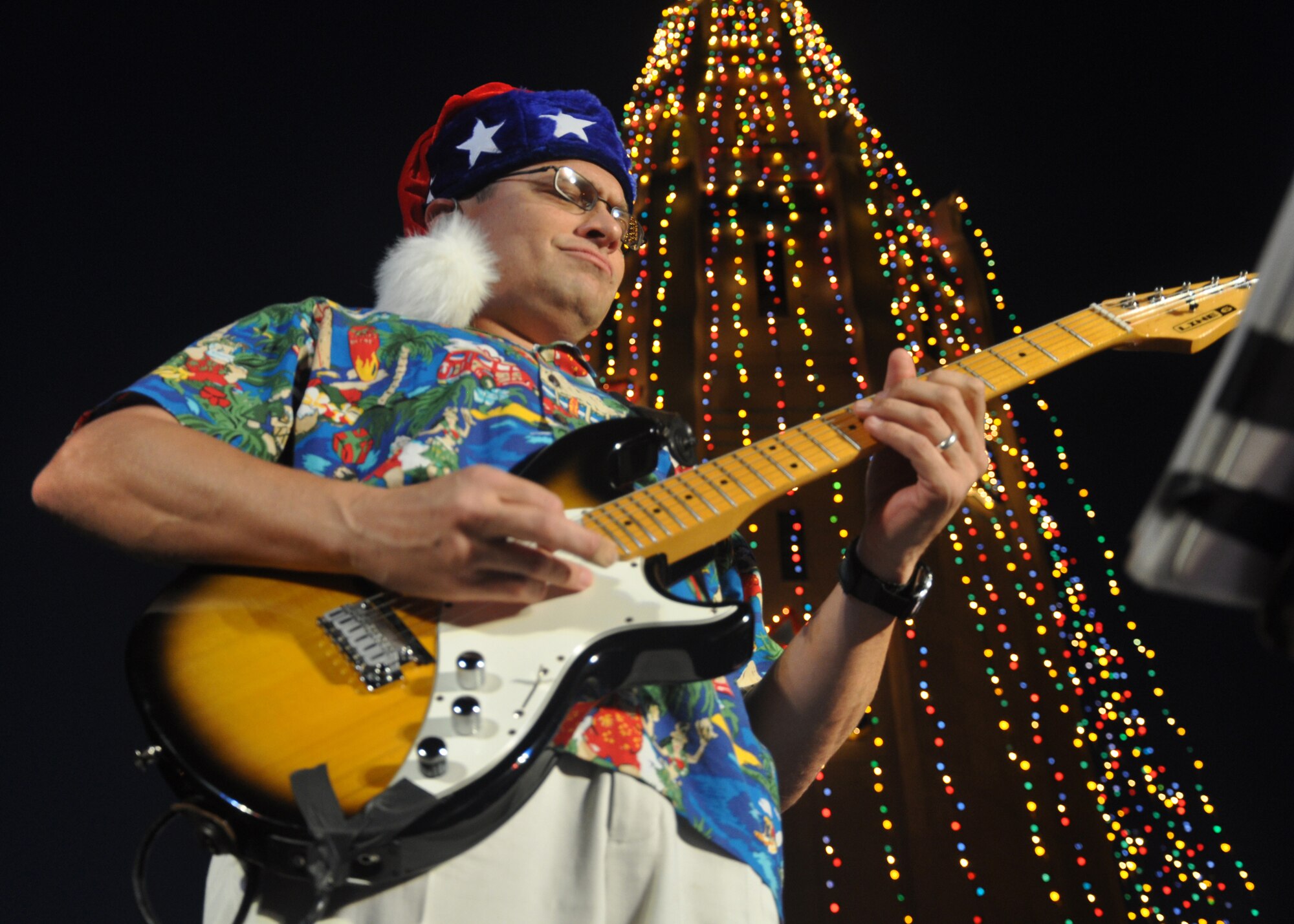 HICKAM AIR FORCE BASE, Hawaii -- Staff Sgt. Gregory Scott Lacy, a musician with Hana Hou, U.S. Air Force Band of the Pacific - Hawaii, performs holiday music during the Freedom Tower Lighting celebration Dec. 4. More than 5,000 multi-colored twinkle lights make the tower Oahu's largest Christmas tree at 171 feet tall. This year marked the 40th anniversary of the freedom tower lighting. Hickam's history reports that it was spared from the Japanese attack on Dec. 7, 1941 because they believed the majestic tower was our place of worship. The tower stored 500,000 gallons of emergency water for the base. (U.S. Air Force photo/Staff Sgt. Mike Meares)