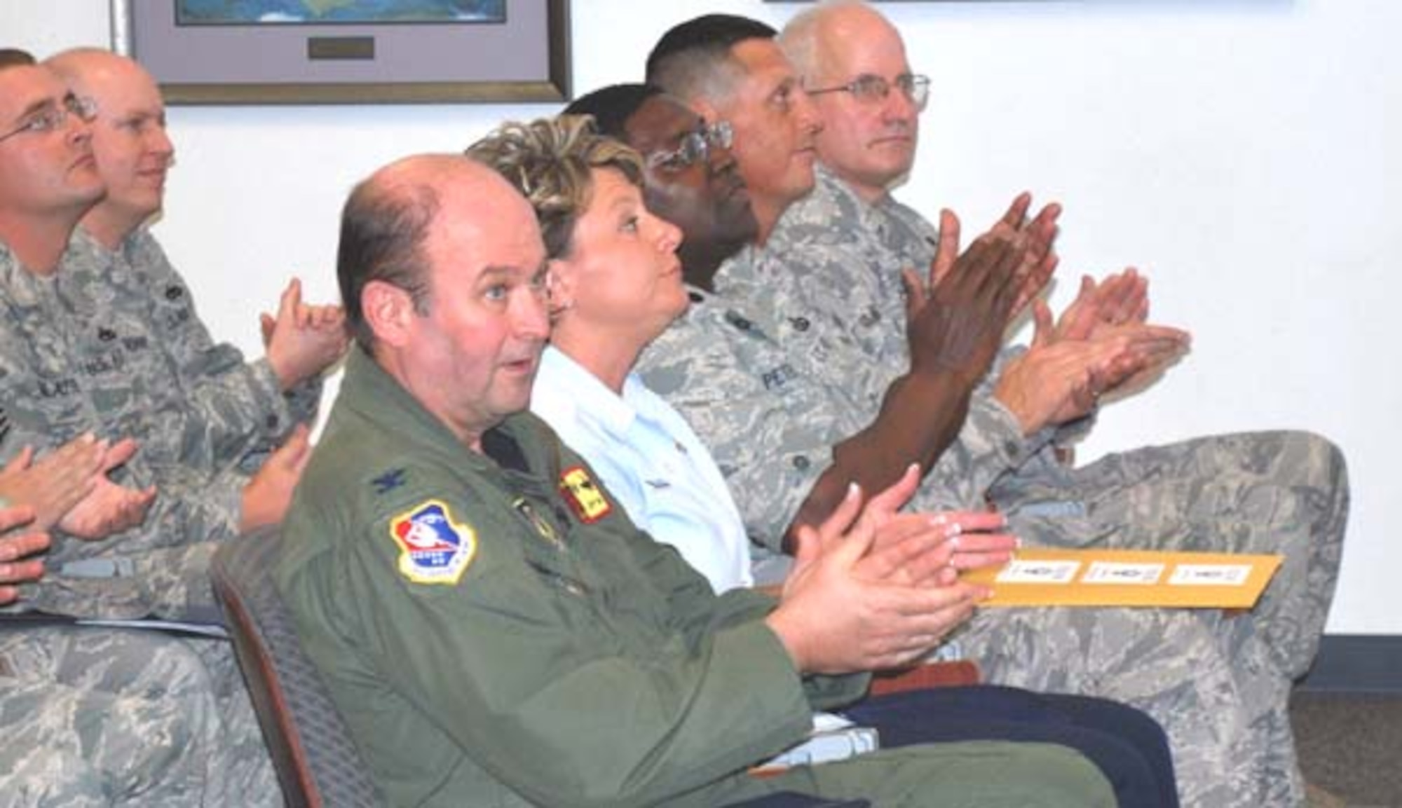 507th Air Refueling Wing and 35th Combat Communications Squadron members respond with applause as they hear the outbrief good news.