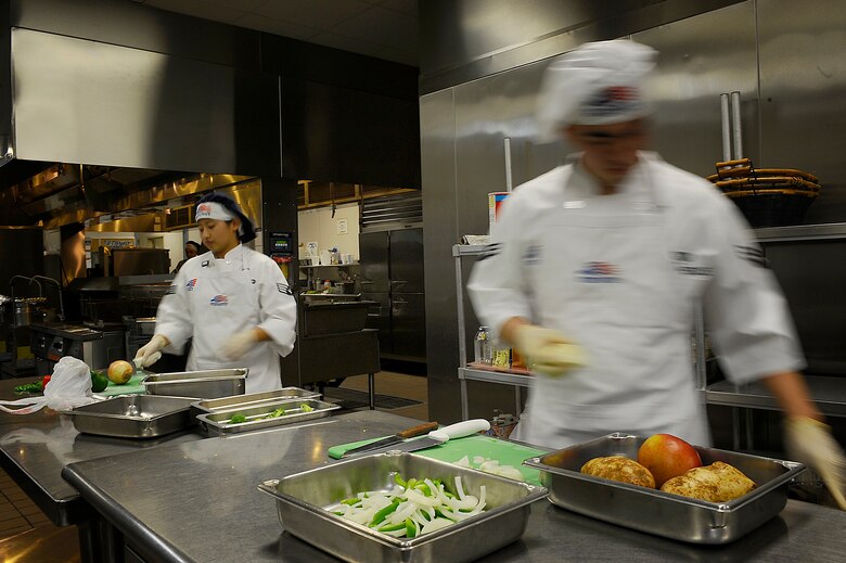 Senior Airman Eun Yi and Airman 1st Class Jorge Farromeque, 1st Special Operations Force Support Squadron food service specialists, dice and slice ingredients for their dishes Dec. 3 at Hurlburt Field. The competitors were given 90 minutes to prepare an entrée with a meat, starch and vegetable component. (Air Force photo by Senior Airman Julianne Showalter)
