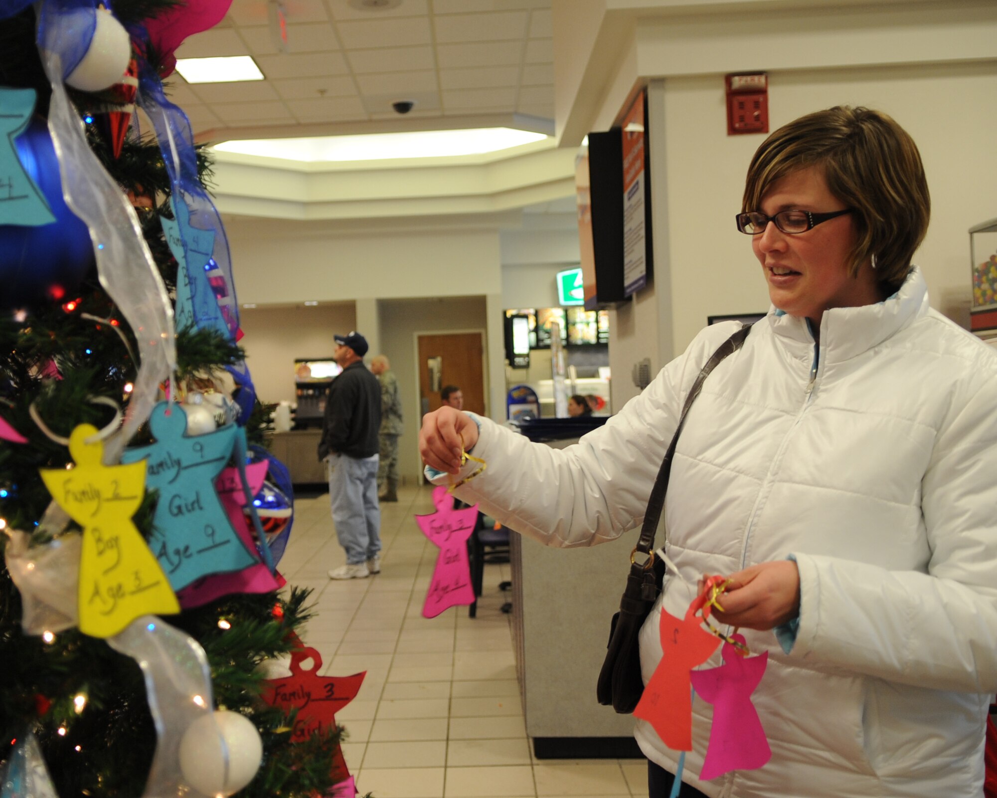 WHITEMAN AIR FORCE BASE, Mo. -Autumn Harrity picks Angel Tree tickets from a holiday tree at the Base Exchange here Dec. 7, 2009. The Angel Tree is a program, ran by the First Sergeants Group, where the public is able to donate a gift to a family in need during the holidays. (U.S. Air Force Photo/ Senior Airman Cory Todd) (Released)