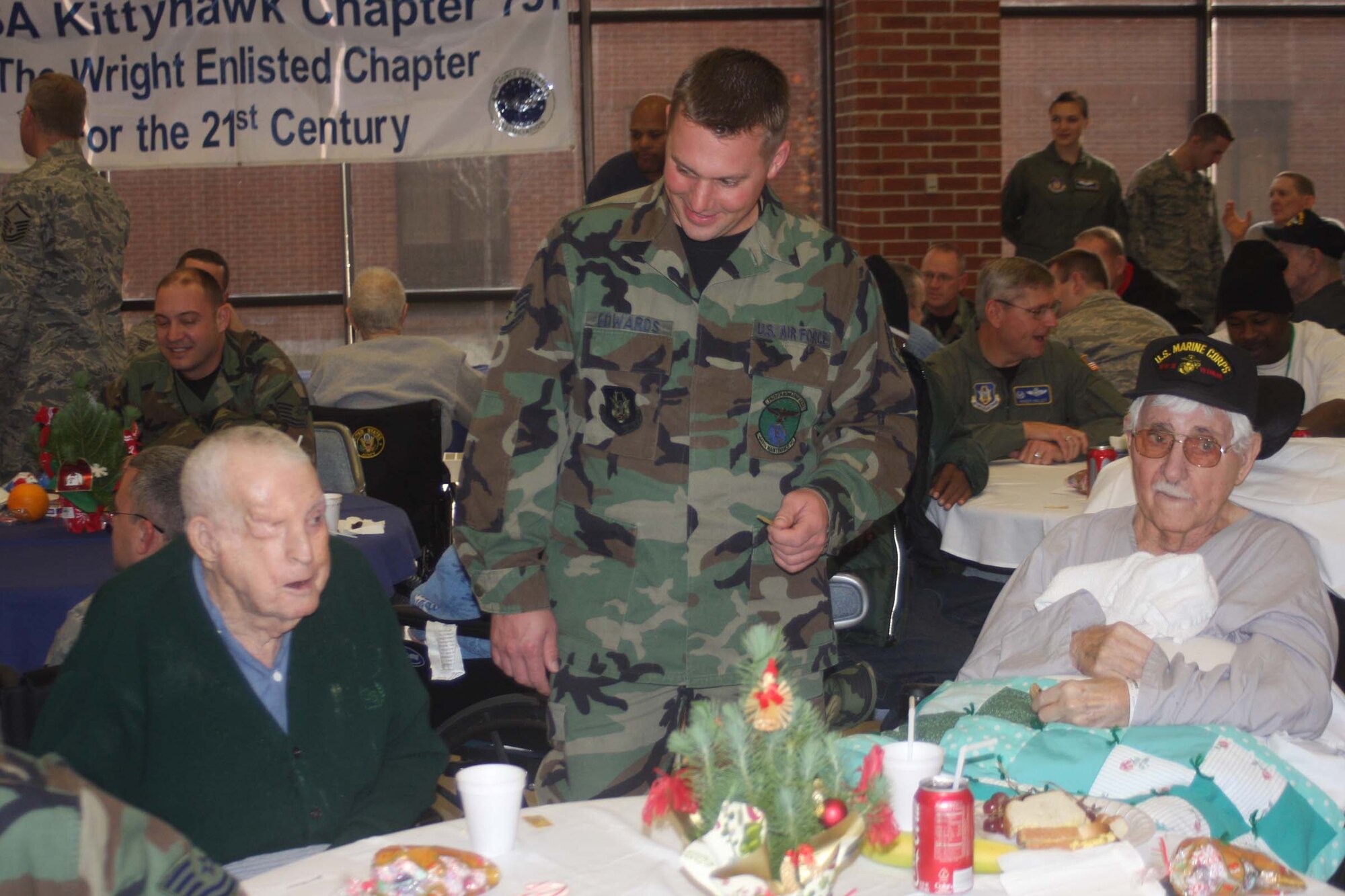 DAYTON, Ohio - Staff Sgt. Joseph Edwards,445th Maintenance Squadron, talks with with veterans at the Dayton Veteran's Affairs Medical Center, Dec. 5 during the annual VA Christmas party.  Airmen of 445th Airlift Wing attend the event and provide gifts and companionship to local VA residents each year. (Air Force photo/Senior Airman Matthew Cook) 