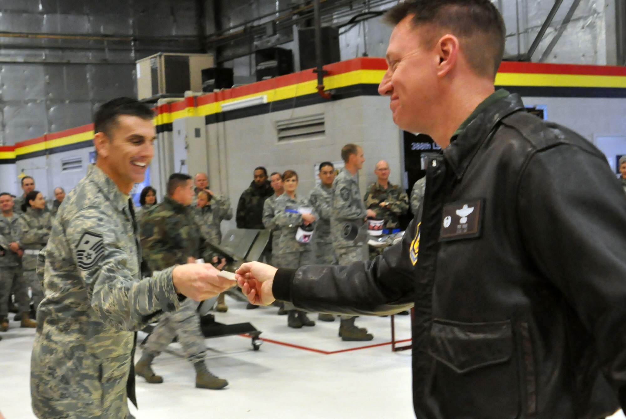 Lt. Col. Pat Wade, 466th Fighter Squadron commander, passes an index card to Master Sgt. Christopher Sayre, 419th Security Forces first sergeant, during the December UTA commander’s call. First sergeants distributed the index cards so Airmen could ask questions anonymously. Col. Walter “Buck” Sams, 419th Fighter Wing commander, answered several questions at the end of the meeting. The remaining questions will be answered and made available on the wing Web site. (U.S. Air Force photo/Senior Airman Brandon Craig)