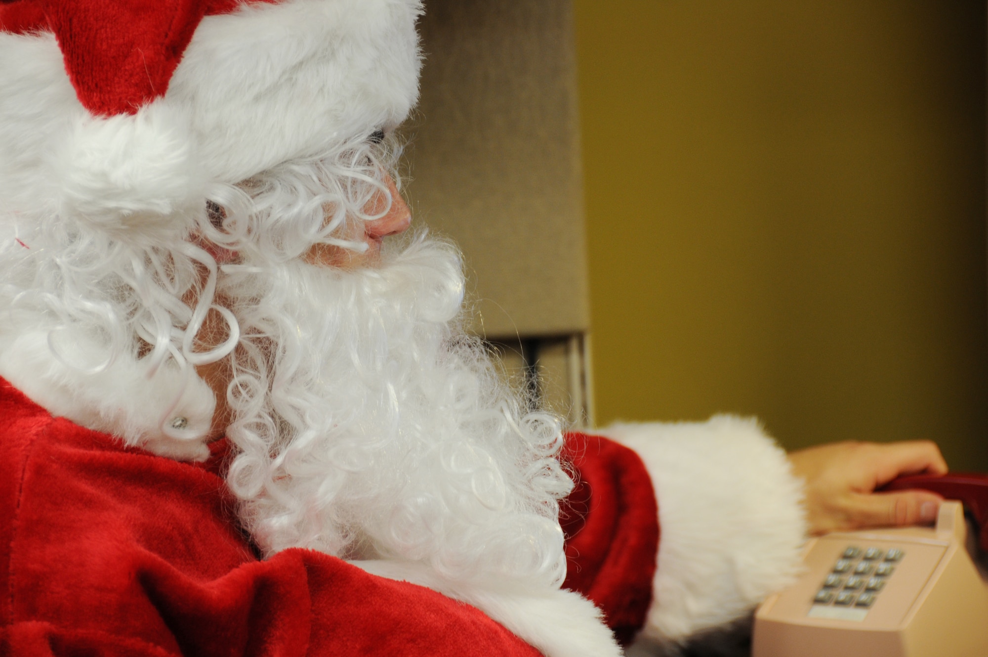Santa picks up another call on the “Santa Hotline” to talk with boys and girls before he makes his holiday journey.  The “Hotline” will be active Dec. 14-18 from 5 p.m. to 9 p.m.  Children of all ages wishing to call in with last-minute holiday wishes can call 850-882-NOEL (6635).  (Air Force photo/ Samuel King Jr.) 