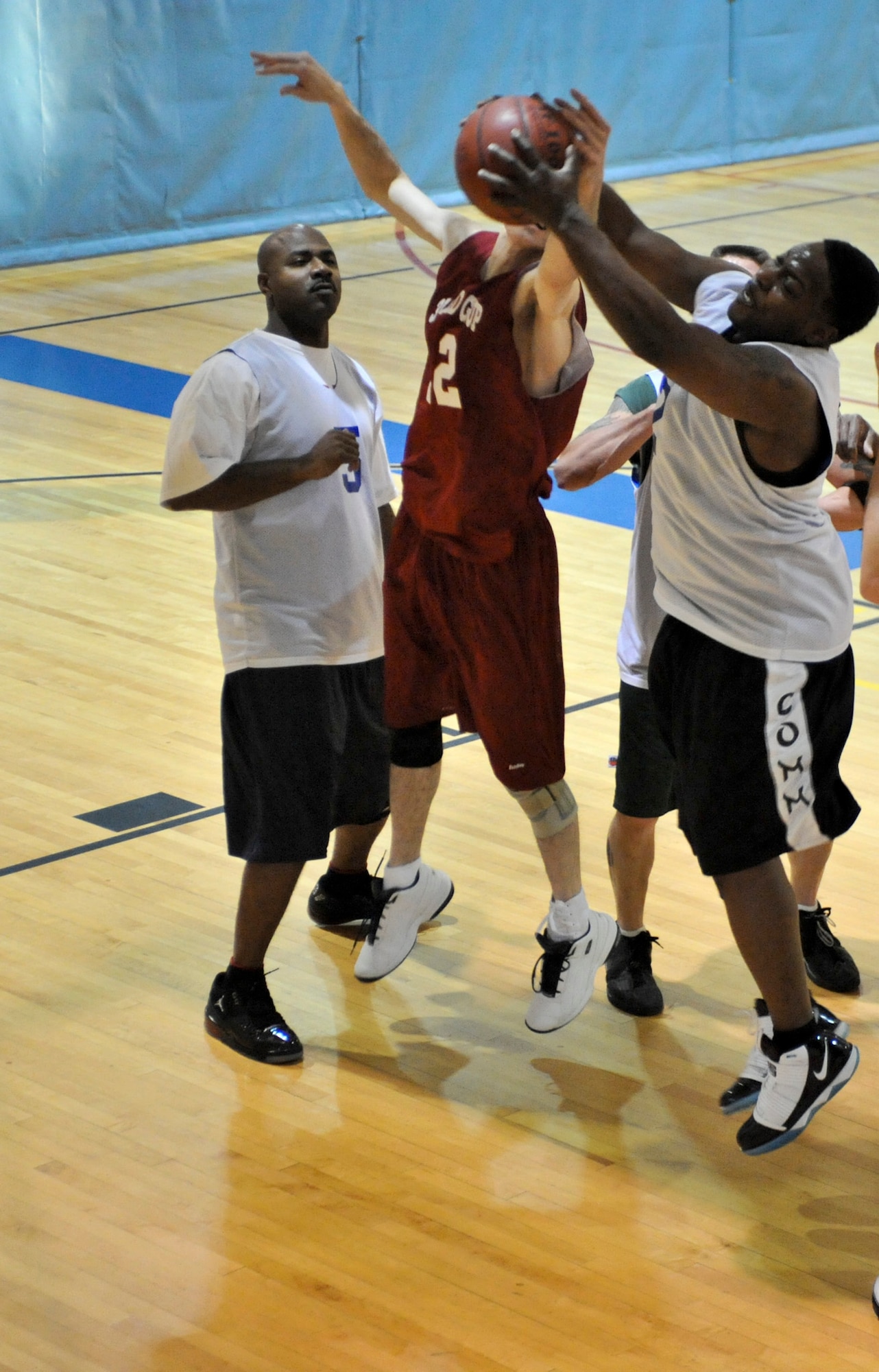 ELMENDORF AIR FORCE, Alaska -- The 381st Intelligence Squadron's Anthony Veasley rebounds the ball over the 3rd Medical Support Squadron's Lee Mills during a game at the Fitness Center Dec. 7. The 3rd MDSS dominated the first half going on a 19-0 run in the opening minutes and held on to the win with a score of 55-39. (U.S. Air Force photo/Airman 1st Class Christopher Gross)