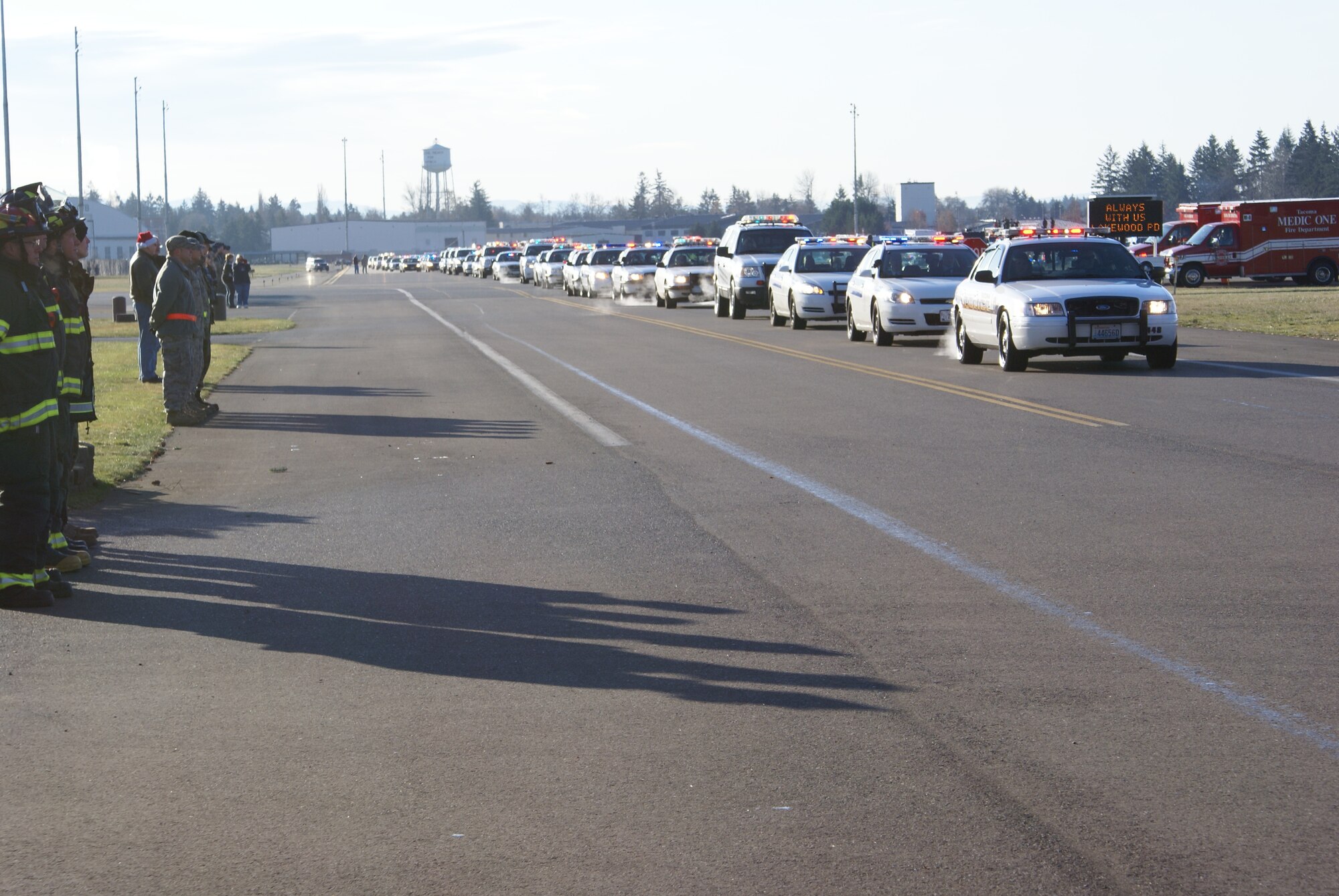 Approximately 2,000 emergency services vehicles from throughout the U.S. and Canada depart McChord Air Force Base Dec. 8 in a procession to the Tacoma Dome Memorial Service honoring four fallen Lakewood, Wash., Police Officers.  McChord Airmen provided a staging area for emergency responders and their vehicles and honored the Lakewood Police Officers by lining the streets of the installation procession route. (U.S. Air Force photo/Staff Sgt. Eric Burks)