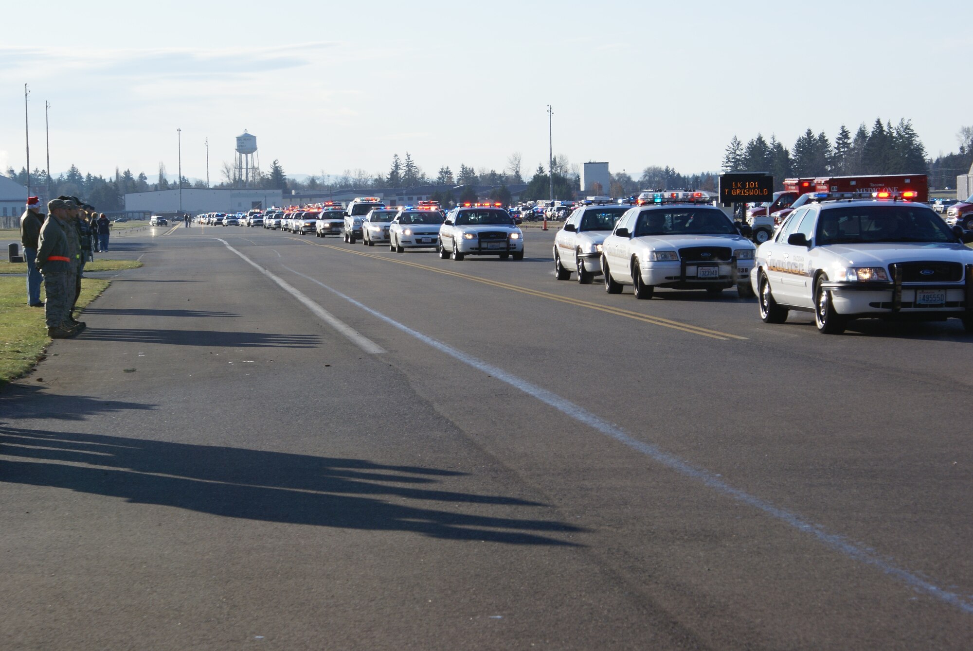 Approximately 2,000 emergency services vehicles from throughout the U.S. and Canada depart McChord Air Force Base Dec. 8 in a procession to the Tacoma Dome Memorial Service honoring four fallen Lakewood, Wash., Police Officers.  McChord Airmen provided a staging area for emergency responders and their vehicles and honored the Lakewood Police Officers by lining the streets of the installation procession route. (U.S. Air Force photo/Staff Sgt. Eric Burks)